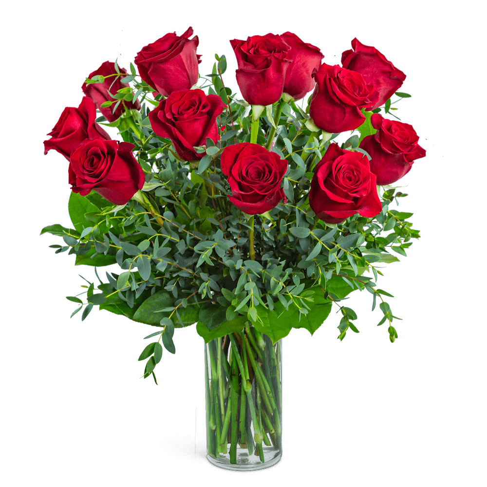 Red roses arranged in a clear glass vase with greenery