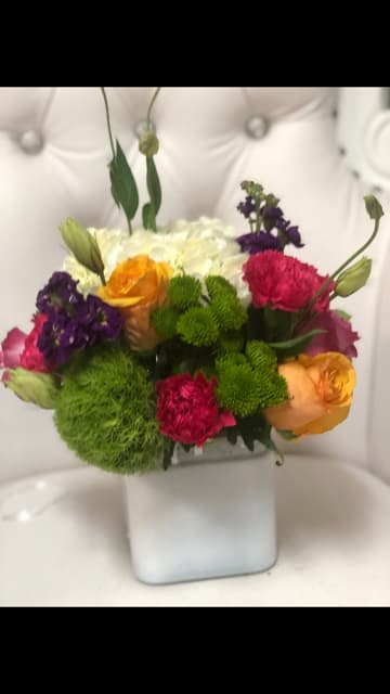 Colorful mixed bouquet in a white square vase