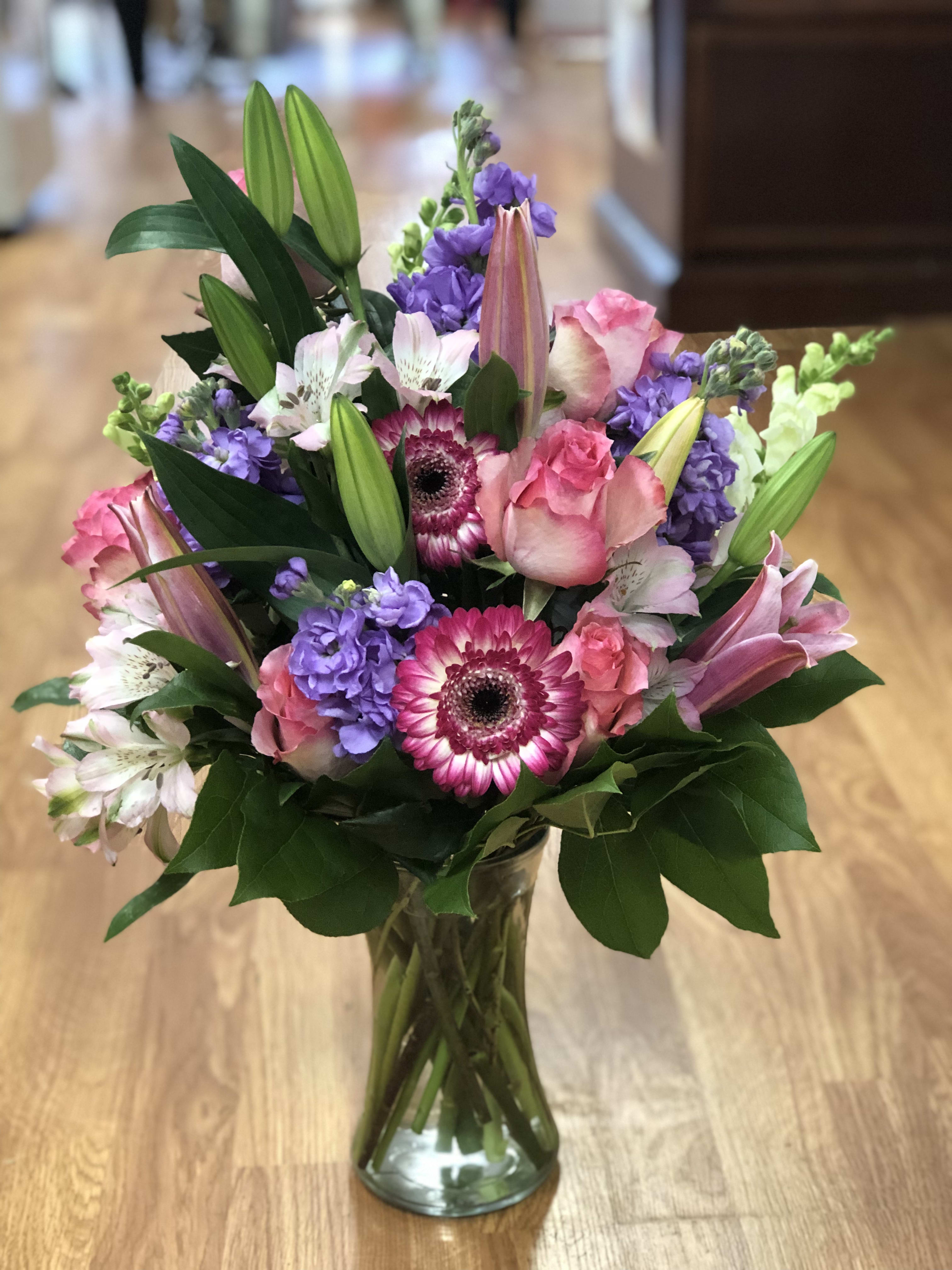 Pink and purple mixed bouquet in a clear glass vase