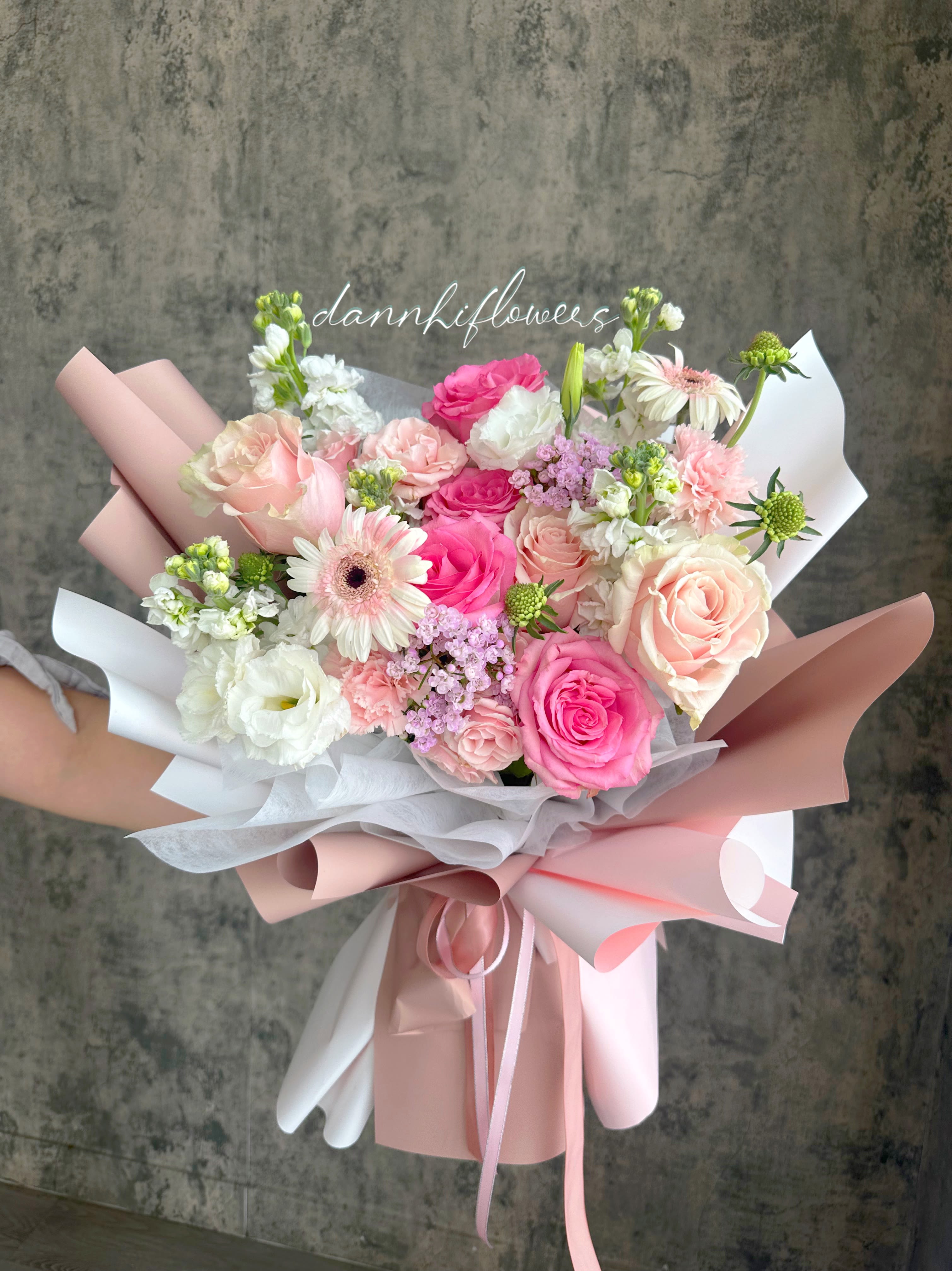 Hand-tied bouquet of pink and white roses with gerbera daisies
