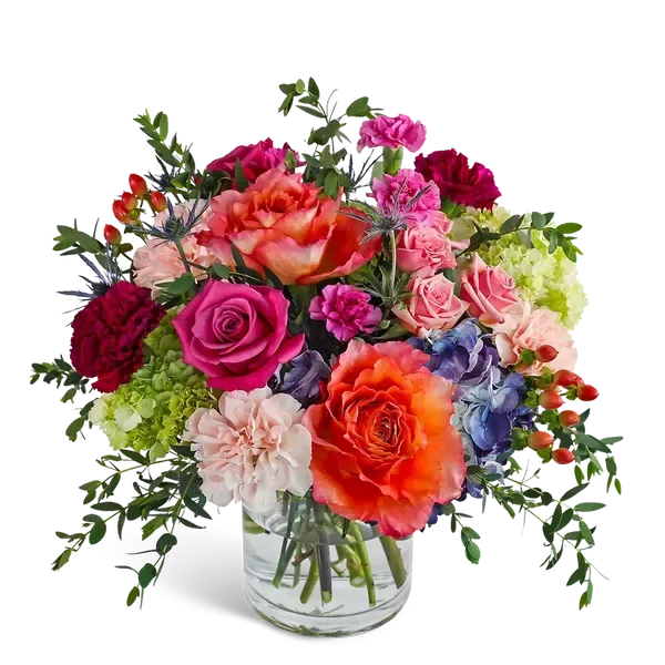 Mixed bouquet of roses, carnations, and hydrangeas in a clear glass vase
