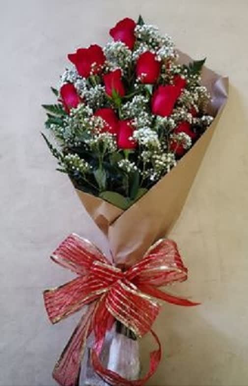 Bouquet of red roses wrapped in brown paper with a red ribbon