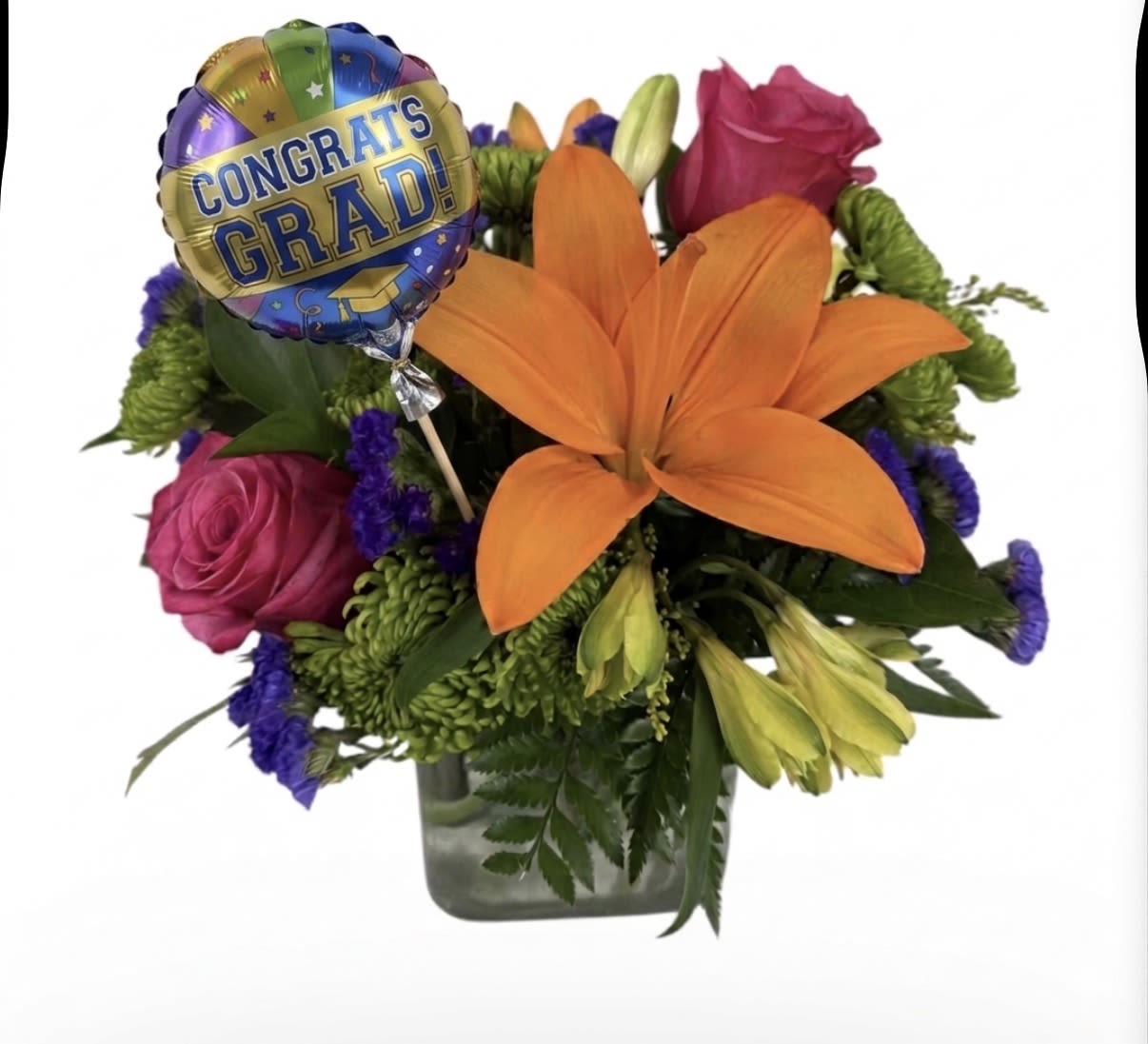 Congrats Grad - A single bold orange lily takes center stage in this graduation flower arrangement, paired with pink roses for a joyful, celebratory feel - the perfect congrats grad bouquet for sending to a new graduate. A round foil balloon that reads "CONGRATS GRAD!" rises above the mix, making the gift instantly festive and unmistakably graduation-focused so the recipient feels honored the moment it arrives. 