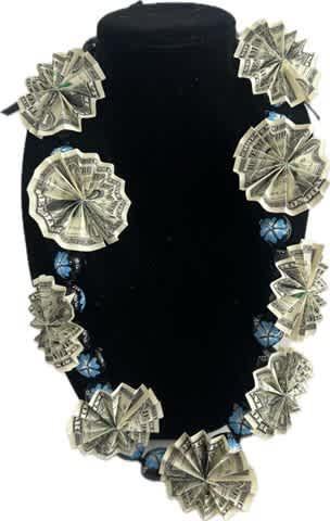 Black velvet necklace display with dollar-bill rosettes and blue bead accents