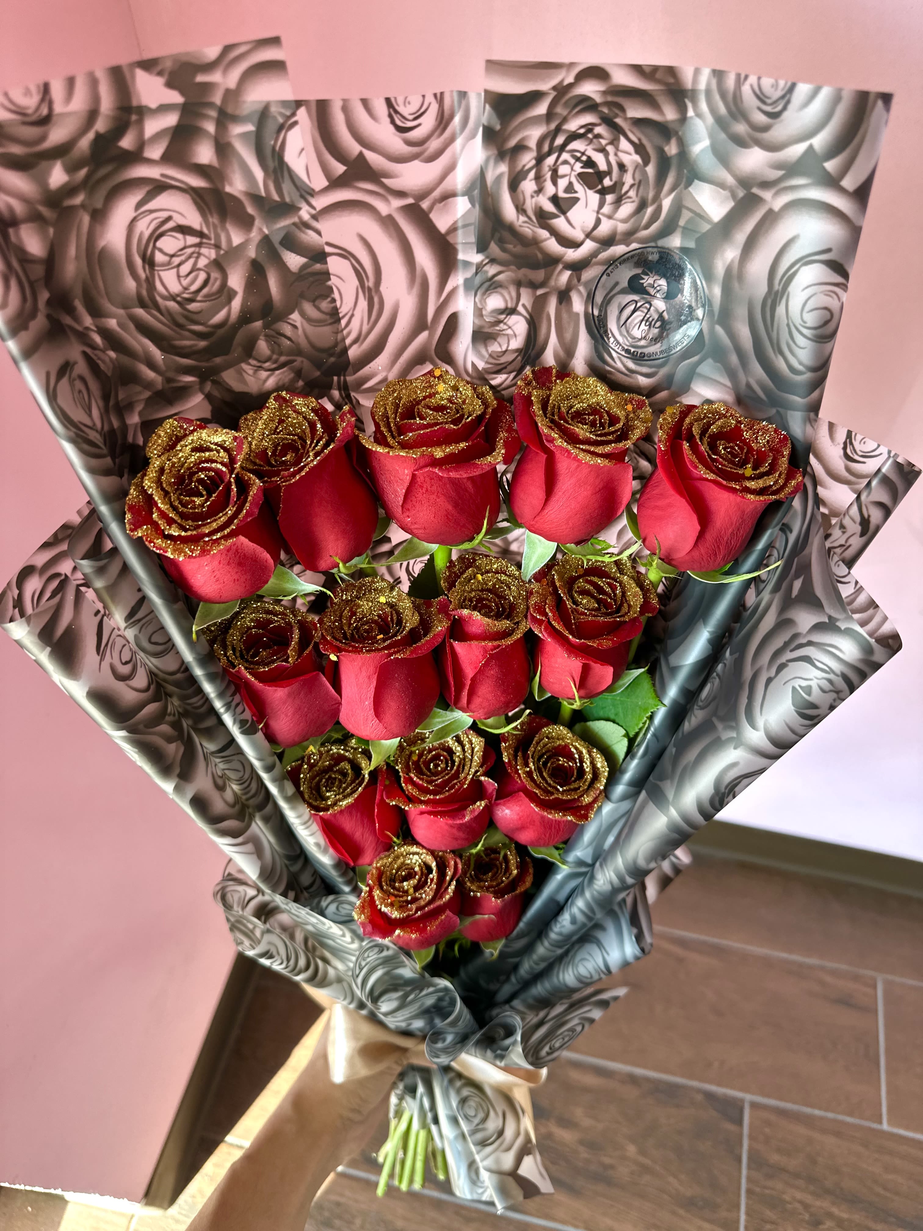 Bouquet of red roses wrapped in black-and-silver floral paper