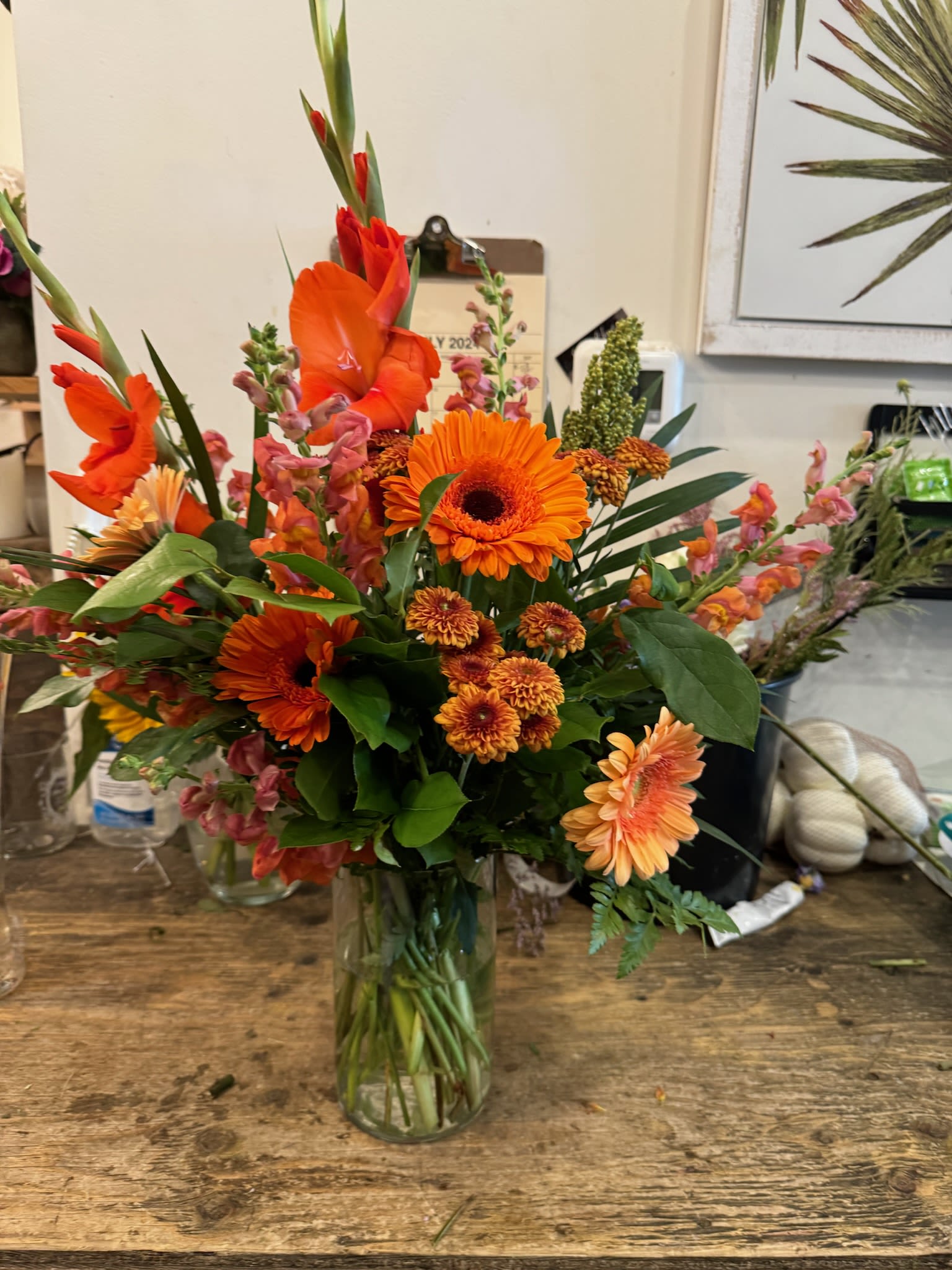 Orange mixed bouquet in a clear glass vase