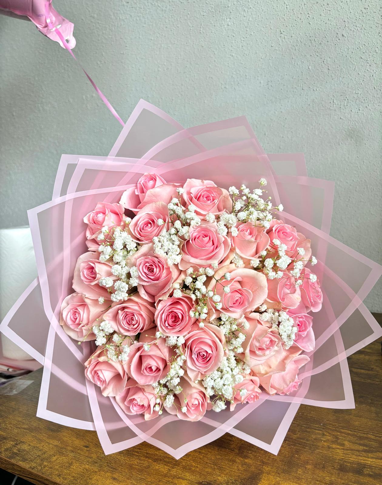 Pink rose bouquet wrapped in translucent pink paper