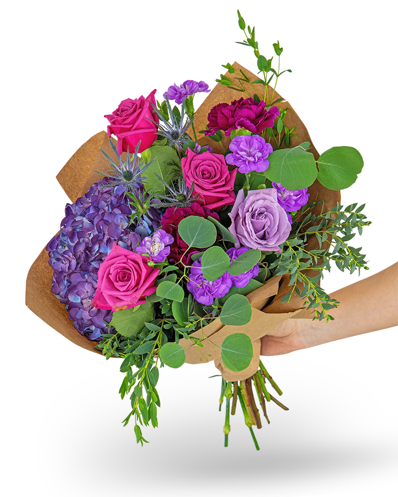Magenta Bouquet - Our Magenta Bouquet features deep purple hydrangea, roses, and carnations, surrounded by a variety of beautiful foliage in a hand-wrapped bouquet. The rich tones of this hand-tied bouquet make it the perfect gift for a friend, family member, or for yourself! Shop your local florist for the freshest and longest-lasting flowers and flower bouquets for your table.   