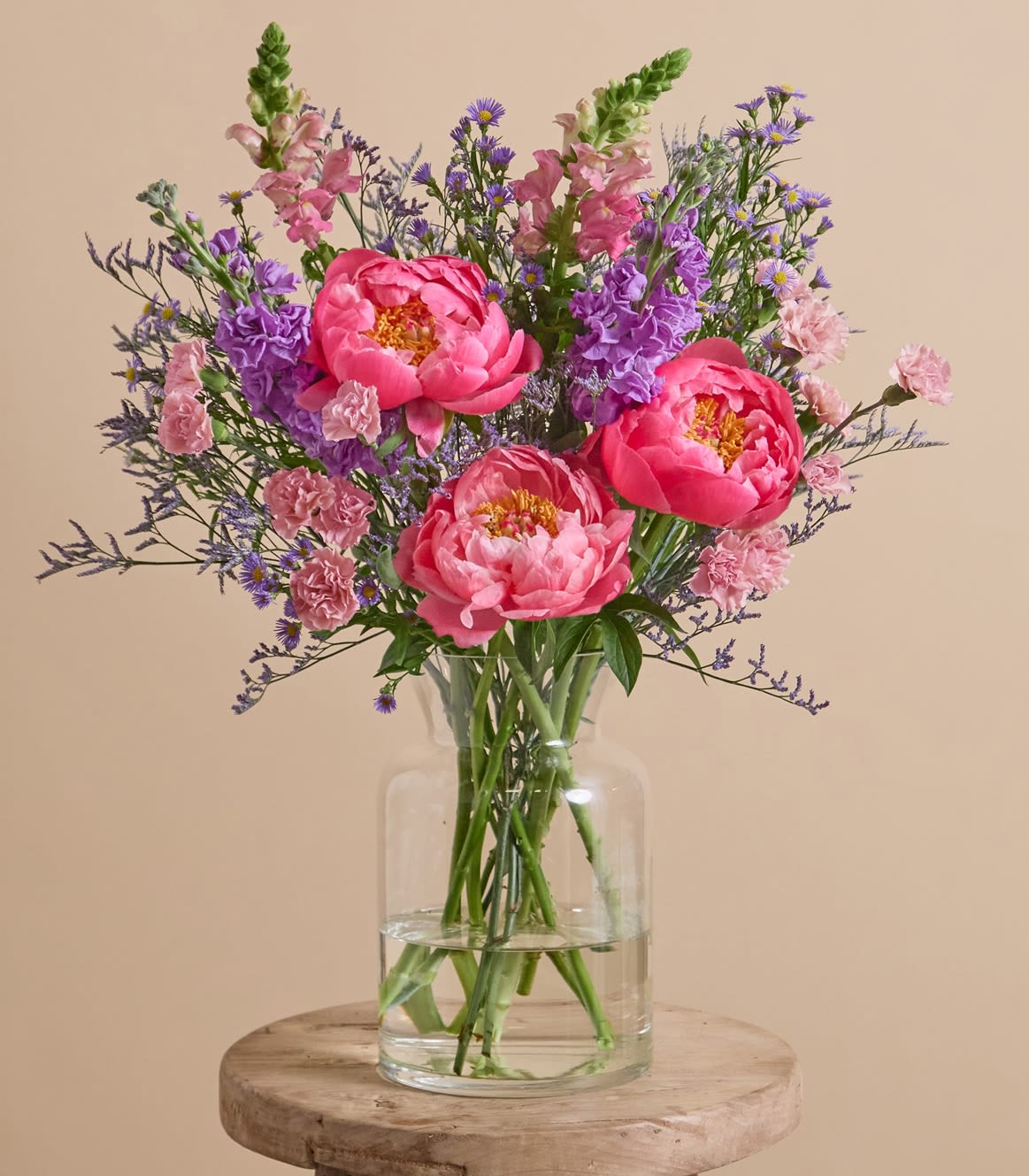 Bring peonies arrangement  - A vibrant burst of saturated pigment, this arrangement puts the spotlight on the season’s most desired stems, peonies. Paired with bold purple stocks, spray carnations, and rich-hued snapdragons against a canvas of lacy limonium and deep-tinted asters.