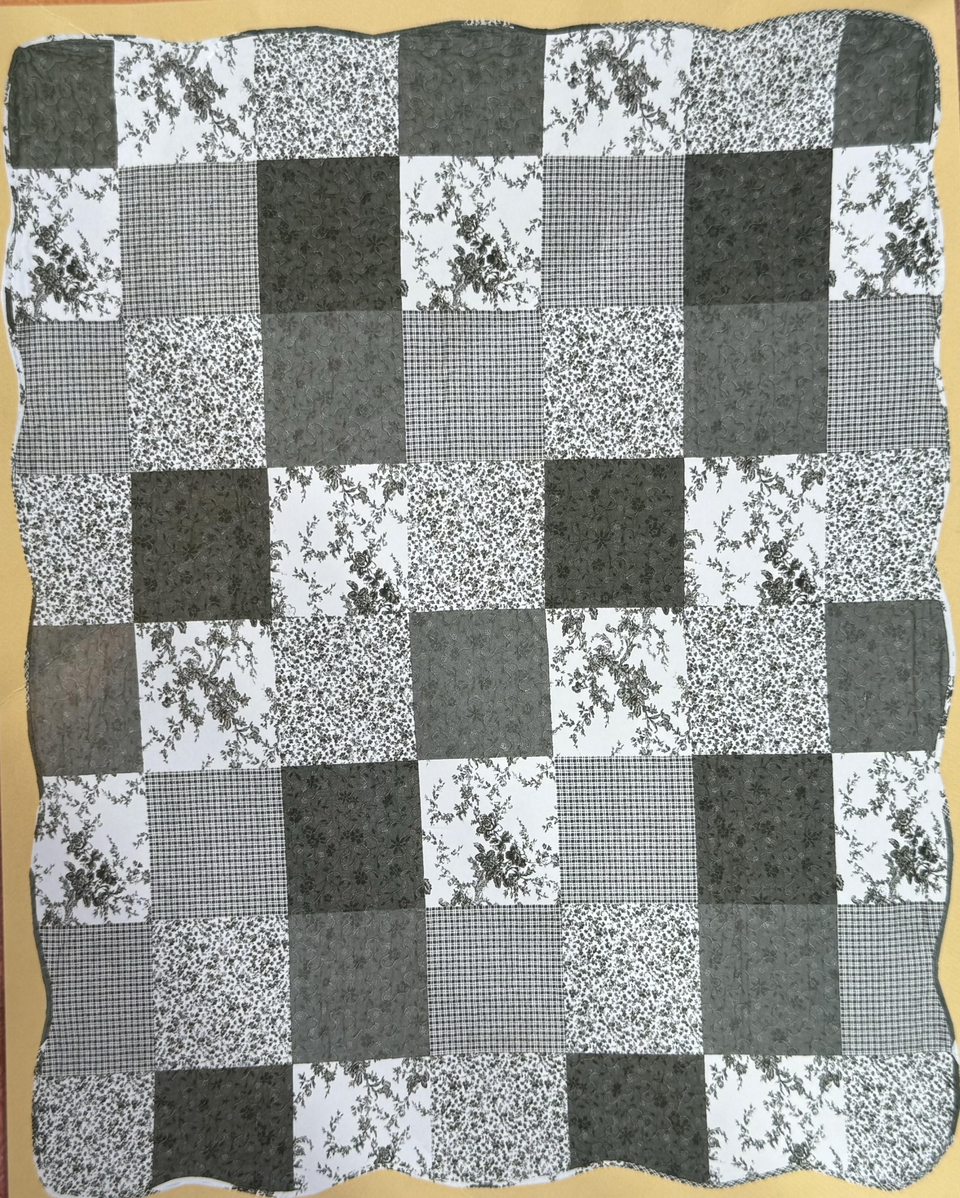 Black-and-white patchwork quilt with floral and checkered squares