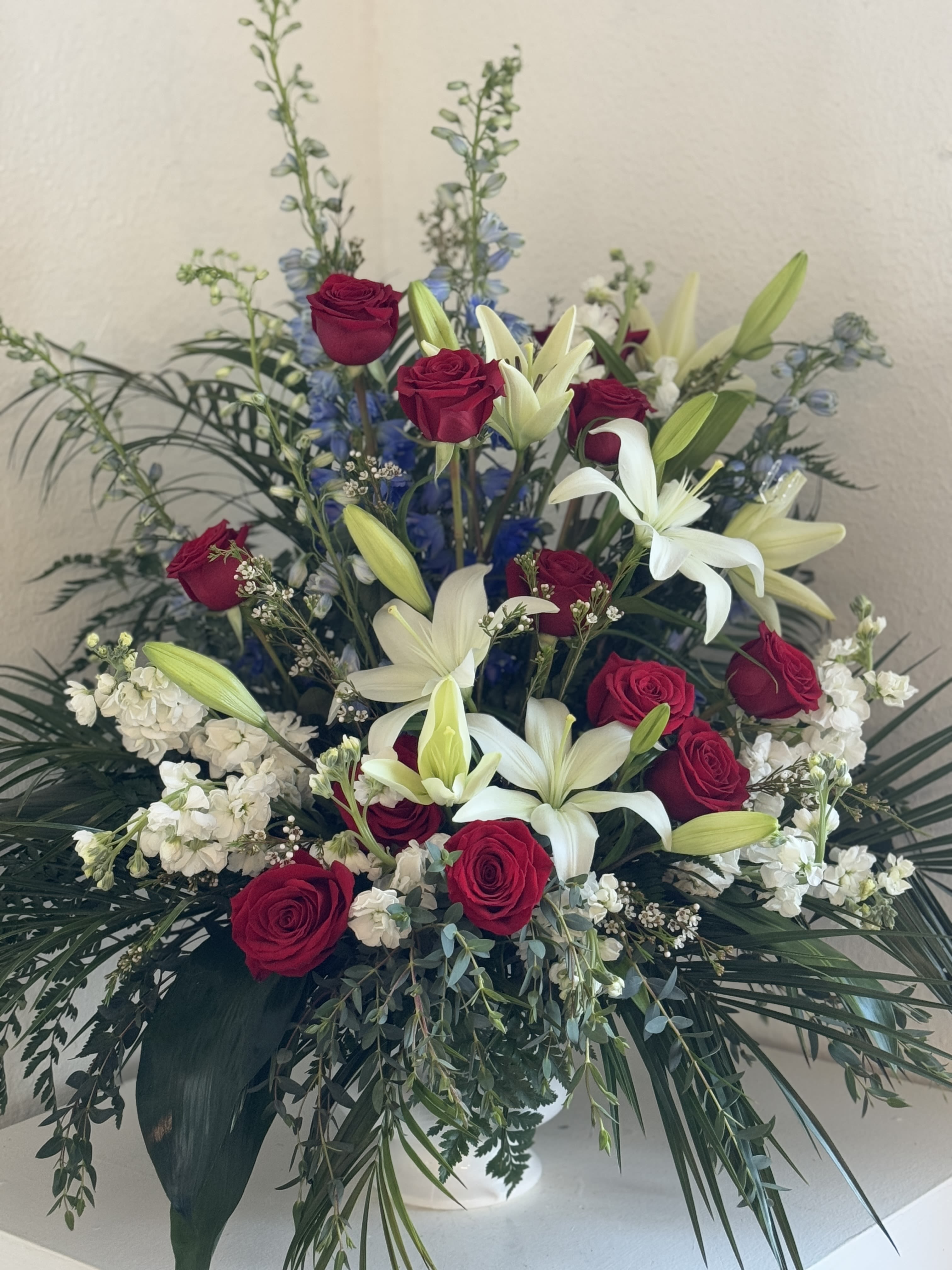 Red roses and white lilies in a large vase arrangement