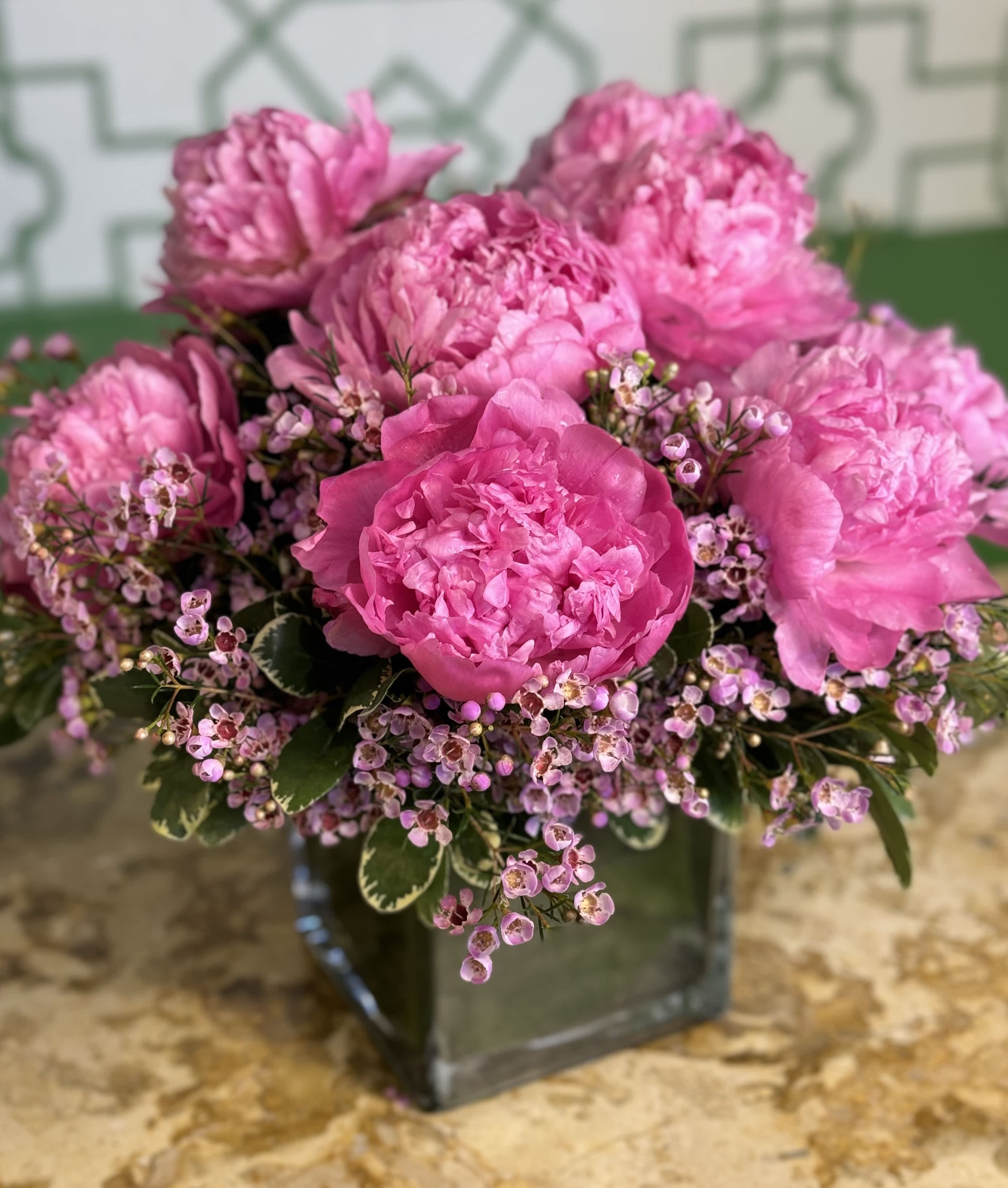 Pink peonies arranged in a square glass vase