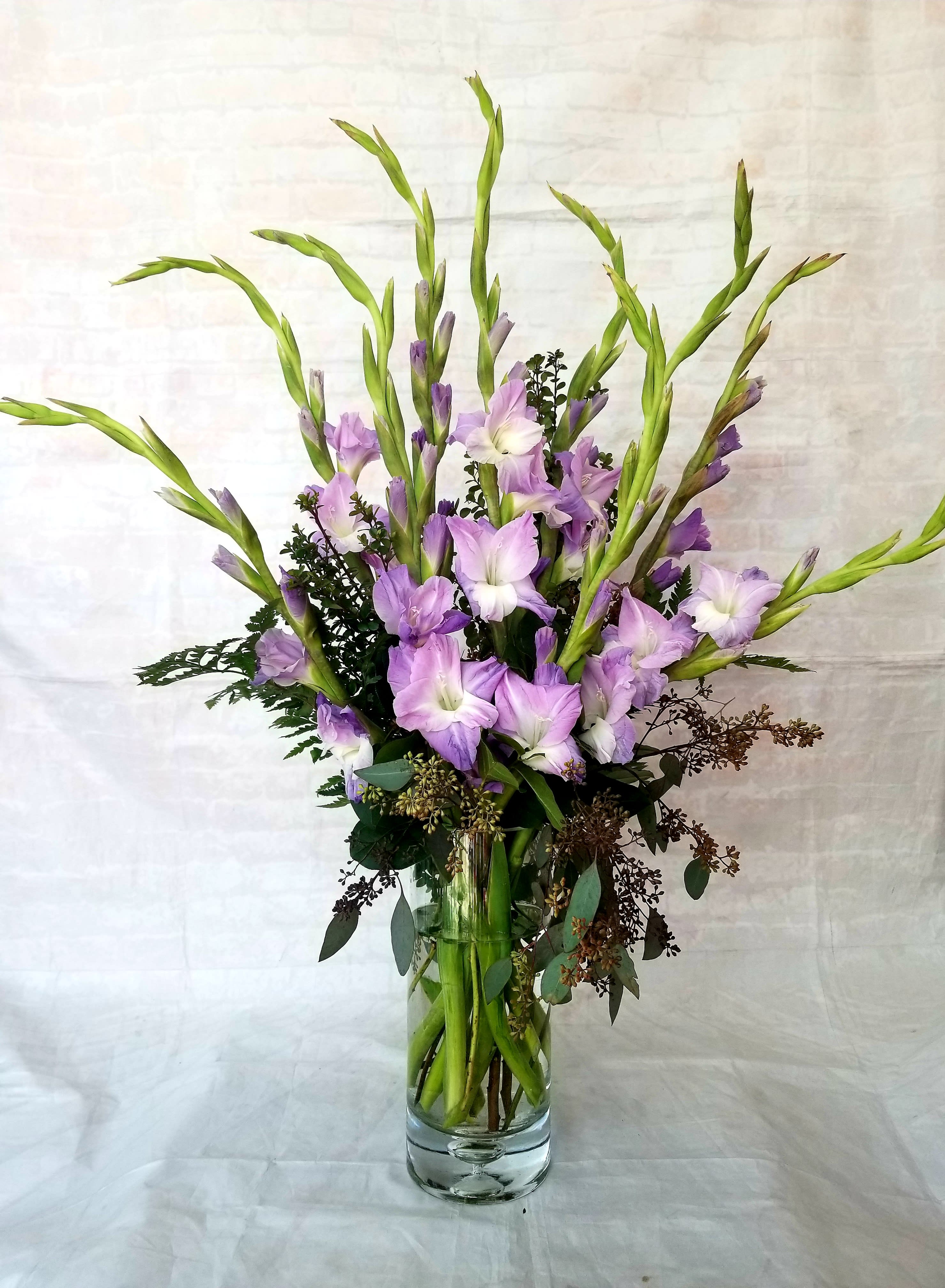 Simply Glads - ***Colors may vary.*** Select this big beautiful arrangement of gladioulas accented with a few stems of greenery.  Call for specific availability or add requests to special instructions and we will do our best to fulfill. 