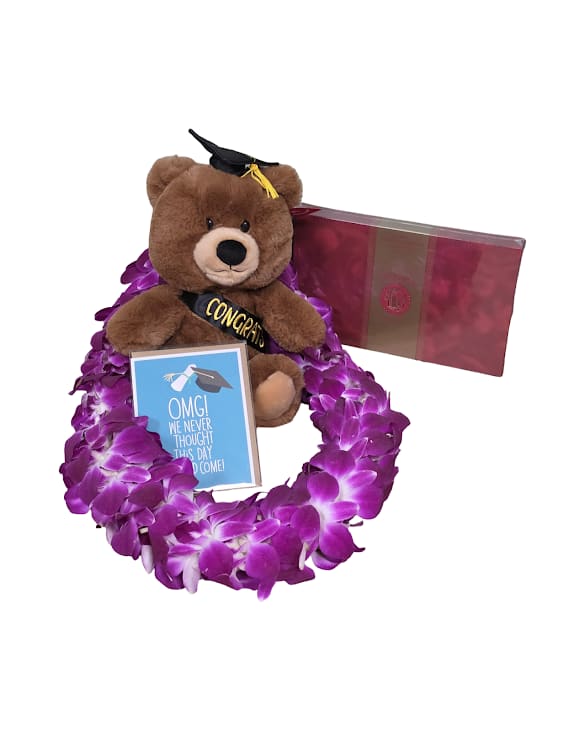 The Celebration Bundle - A playful celebration bundle built to make the grad-or the person you're thinking of-feel truly seen. This bundle for Graduation and "Just Because" moments pairs a vivid purple Bombay orchid lei with a brown teddy bear wearing a black graduation cap and a "CONGRATS" sash, plus a small greeting card and a box of chocolates to complete the presentation.  The orchids' saturated purple tones pop against the plush's neutral brown and the black cap, while hints of pink and blue in the packaging add cheerful contrast. Also included is a box of chocolates for an extra sweet touch. Perfect for saying congrats, marking a milestone, or surprising someone simply because, delivered ready to present.