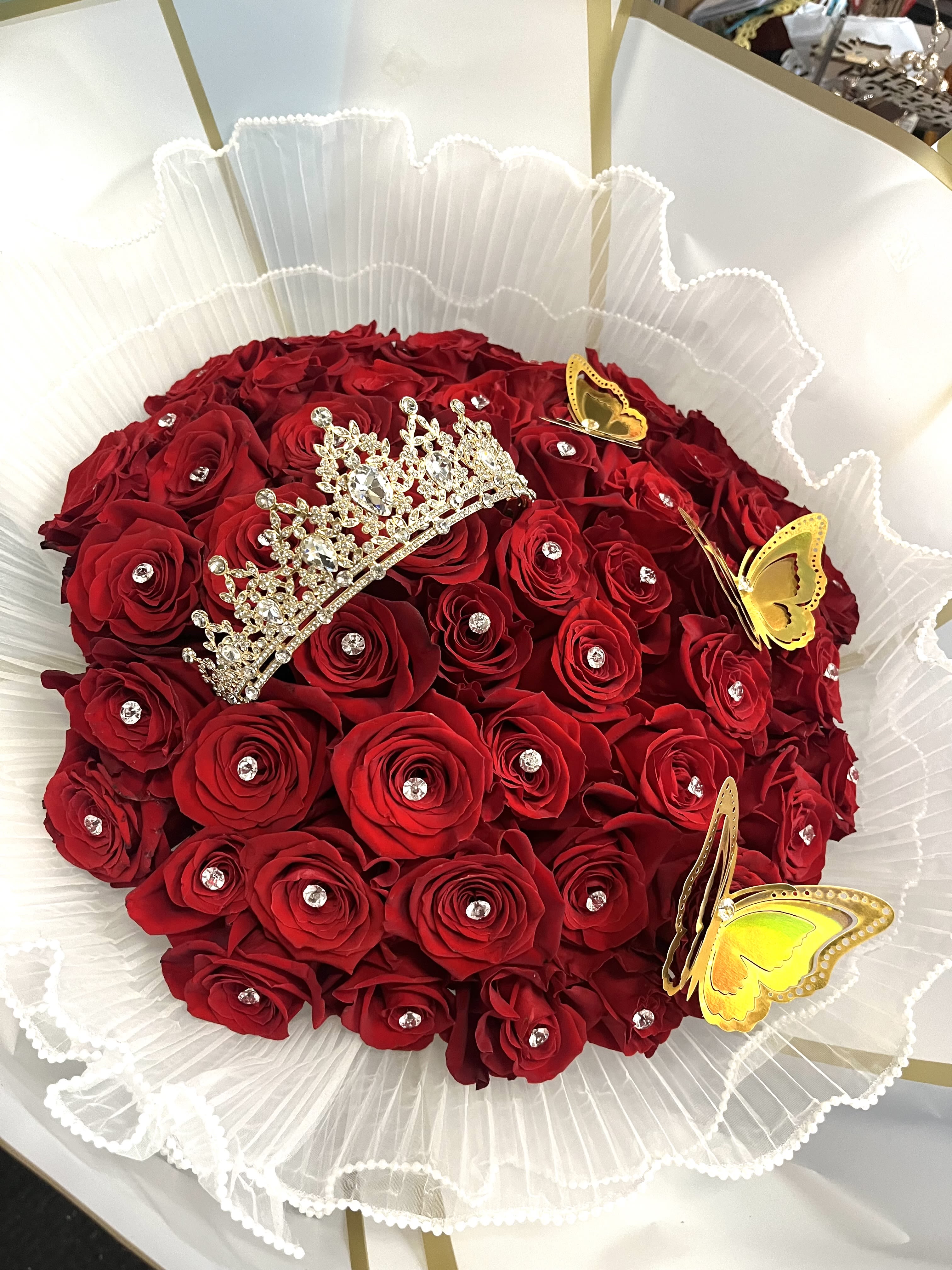 Red rose bouquet with a jeweled tiara and yellow butterfly decorations