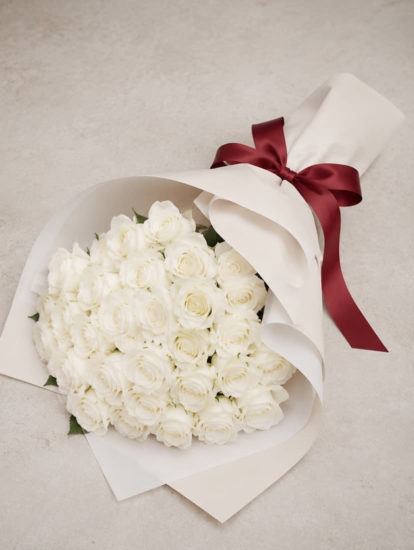Ivory Grace Bouquet - A stunning arrangement of premium white roses, beautifully wrapped in elegant ivory paper and finished with a rich burgundy satin ribbon. Sophisticated, graceful, and perfect for birthdays, anniversaries, engagements, weddings, or meaningful gifts.   Premium fresh roses  Elegant luxury wrapping  Perfect for gifting  Available for online order &amp; delivery  Order now and make someone’s day unforgettable. Visit our website through the link in bio for online orders and more exclusive floral collections.