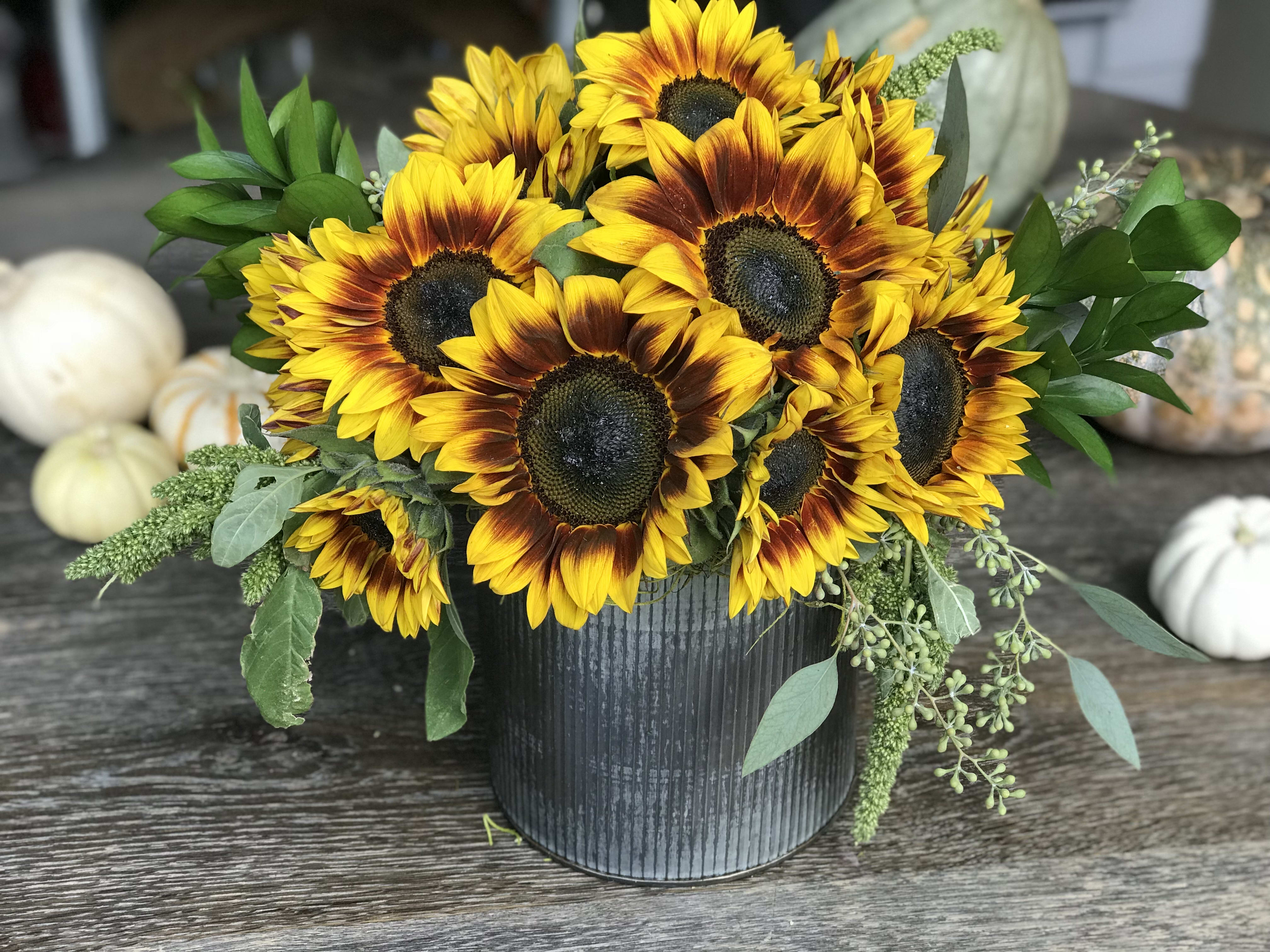 Sunflower arrangement in a black ribbed container