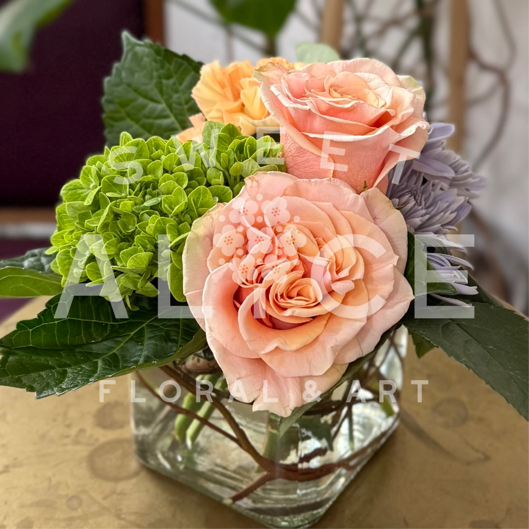 In The Garden - Peachy roses, bold green hydrangea, chrysanthemums, and carnations create a vibrant garden scene.