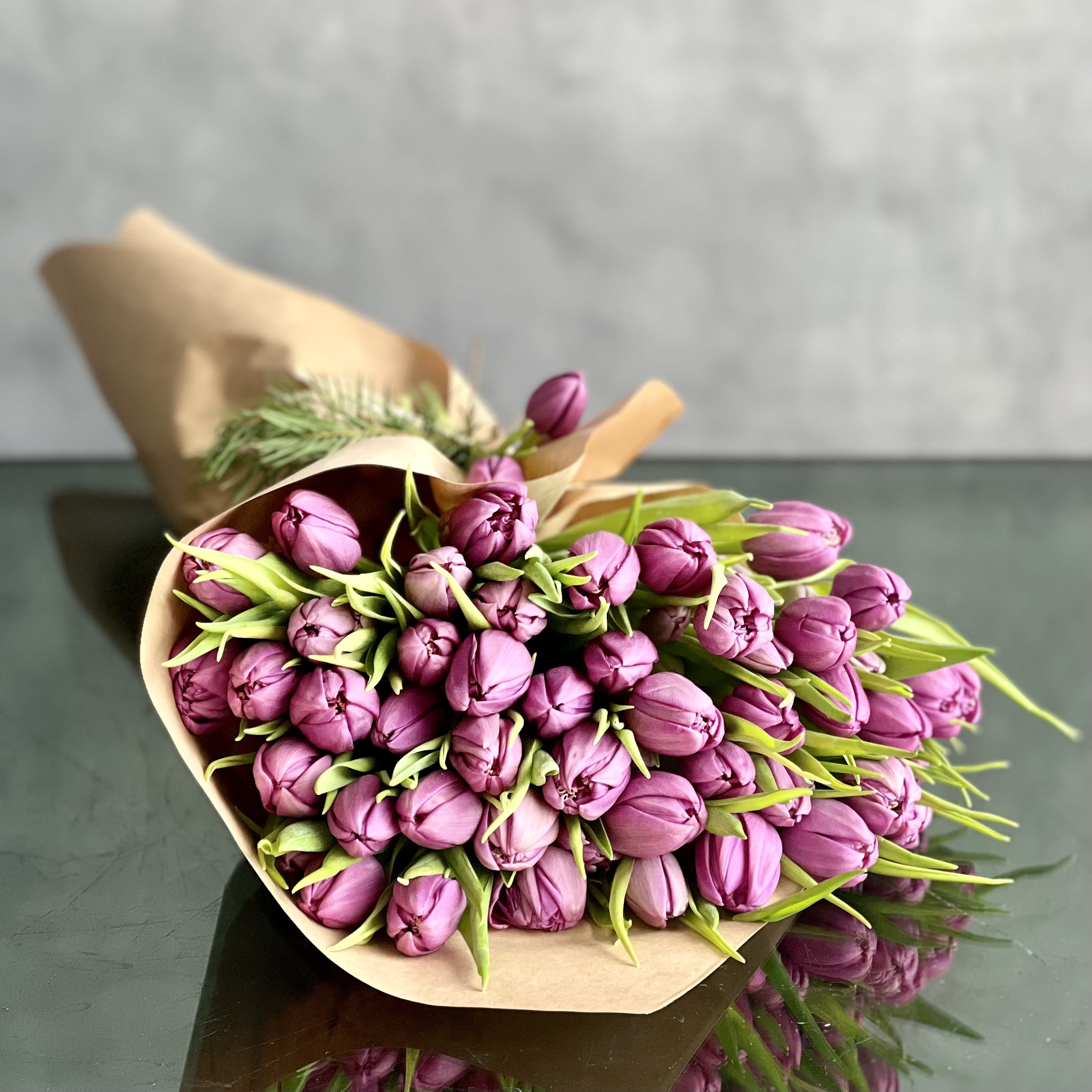 Bouquet of purple tulips wrapped in brown paper