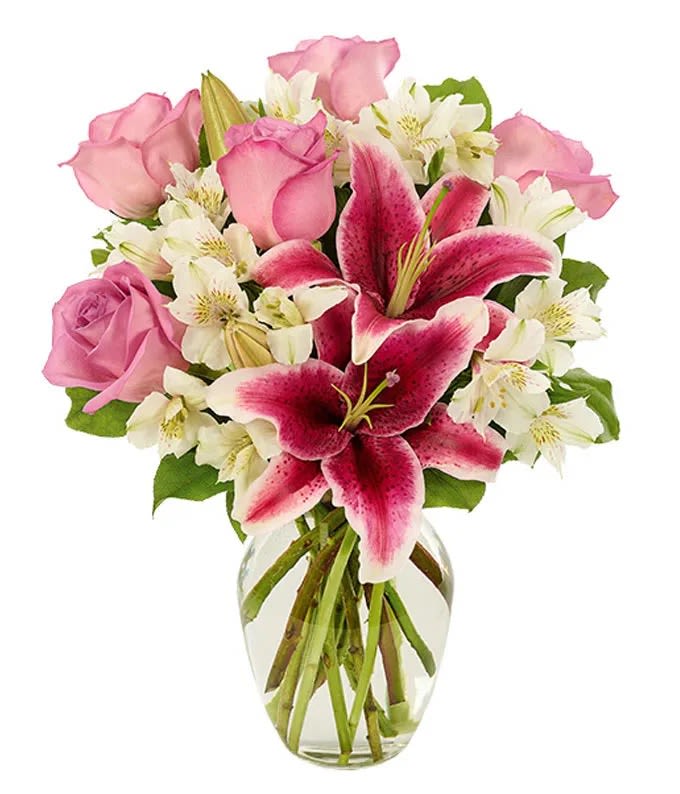 Pink roses and white lilies in a clear glass vase