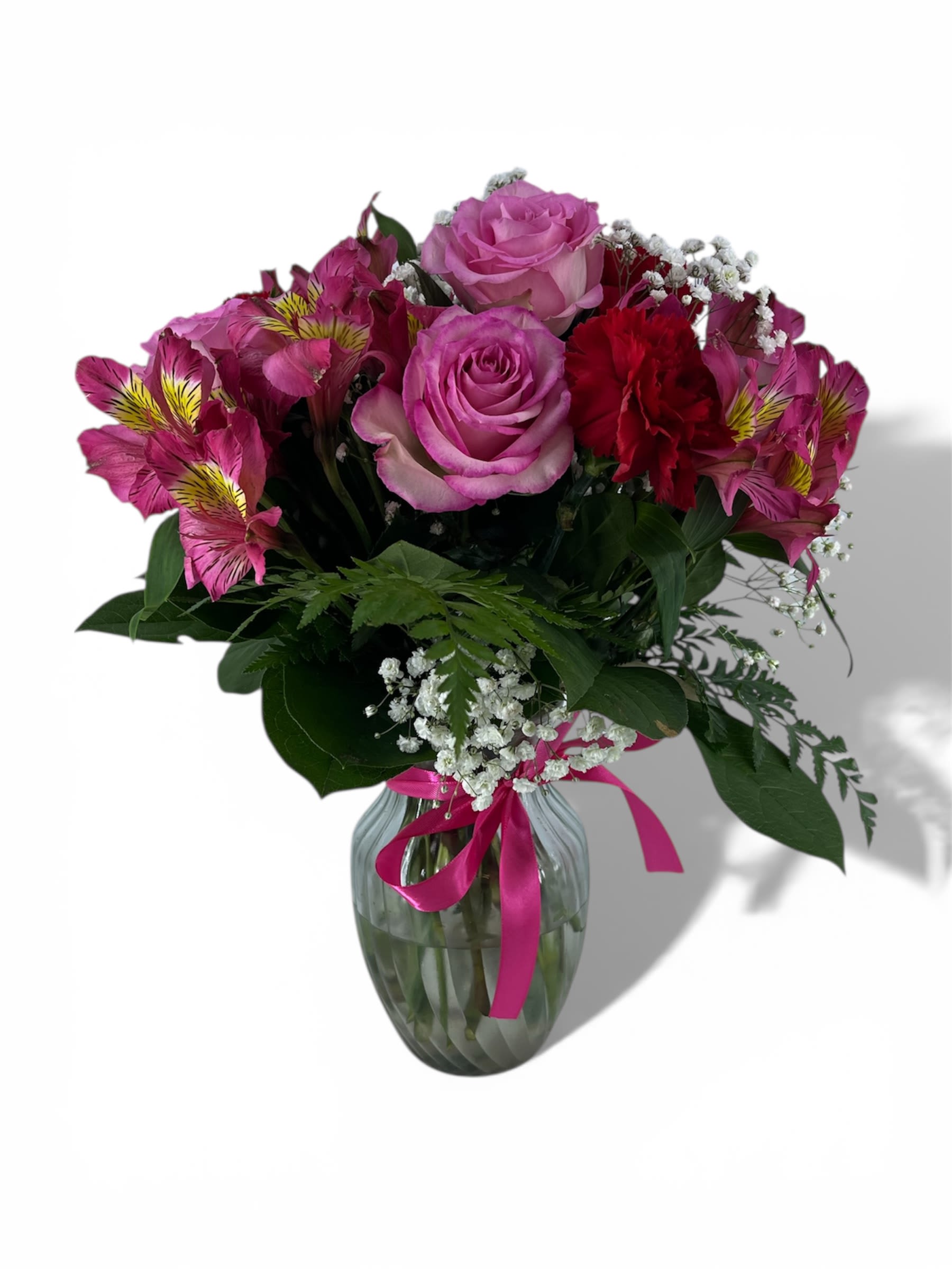 Pink and red mixed bouquet in a glass vase with a ribbon
