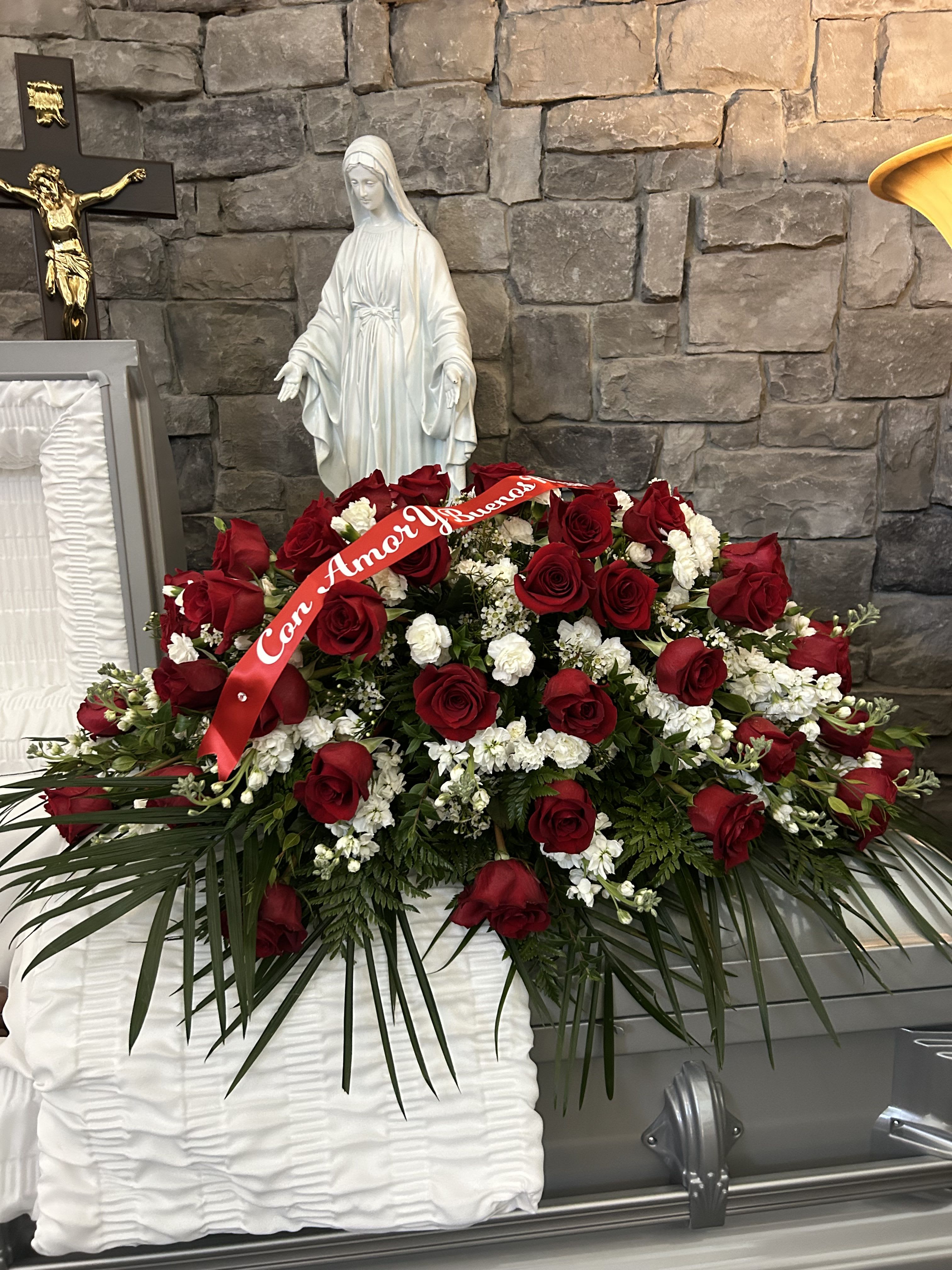 Large red rose funeral spray with white flowers and a red ribbon