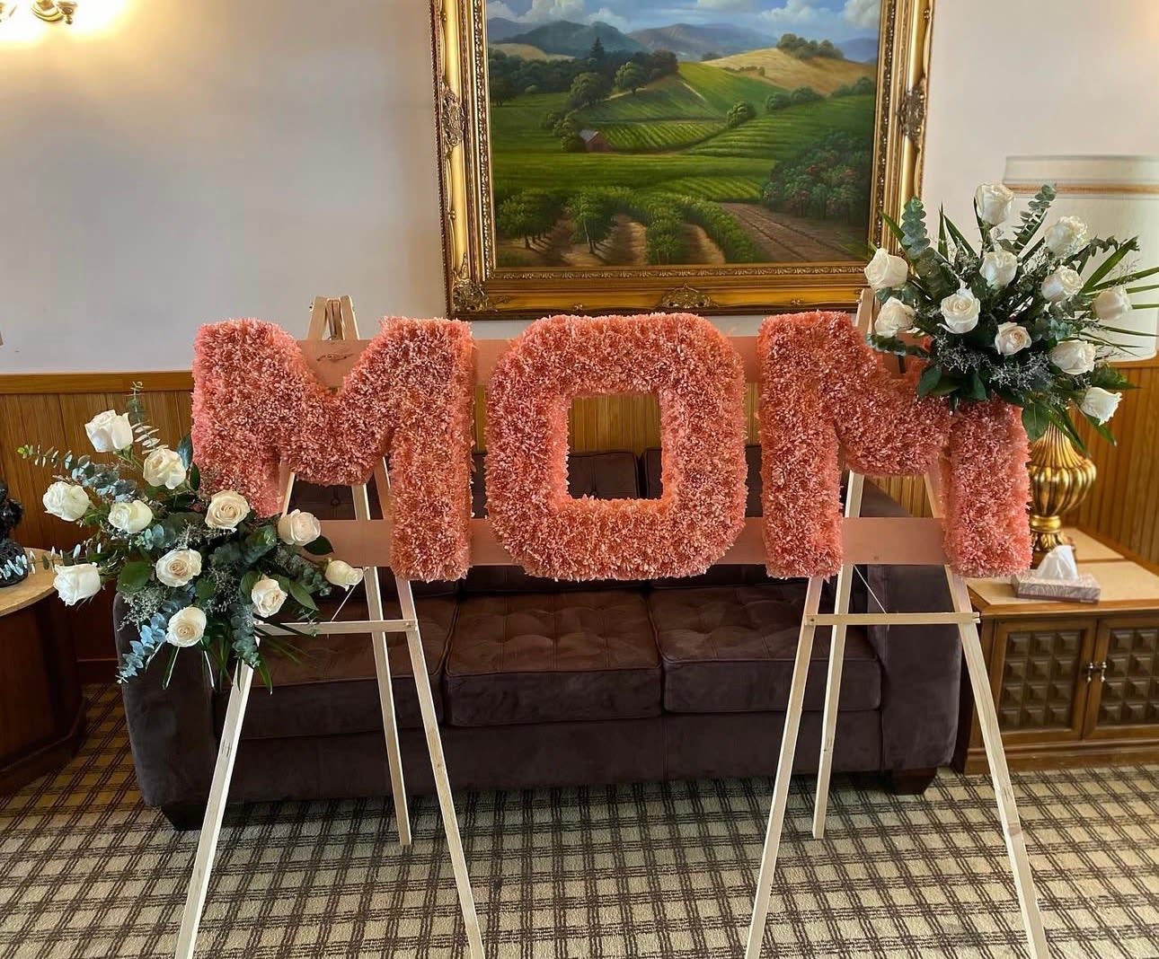 Pink floral letters on easels with white rose arrangements on both sides