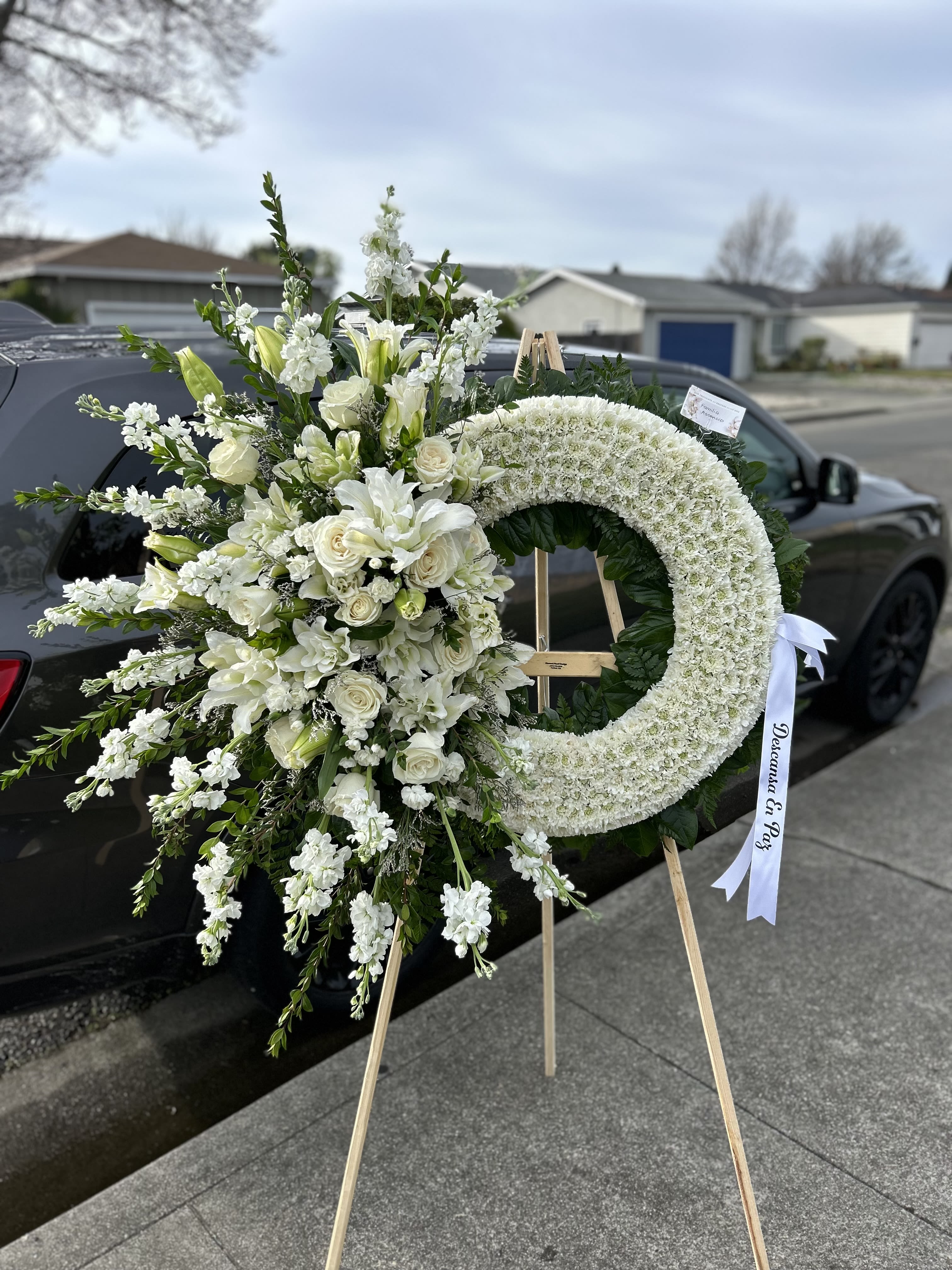 White funeral wreath and matching floral spray on easels