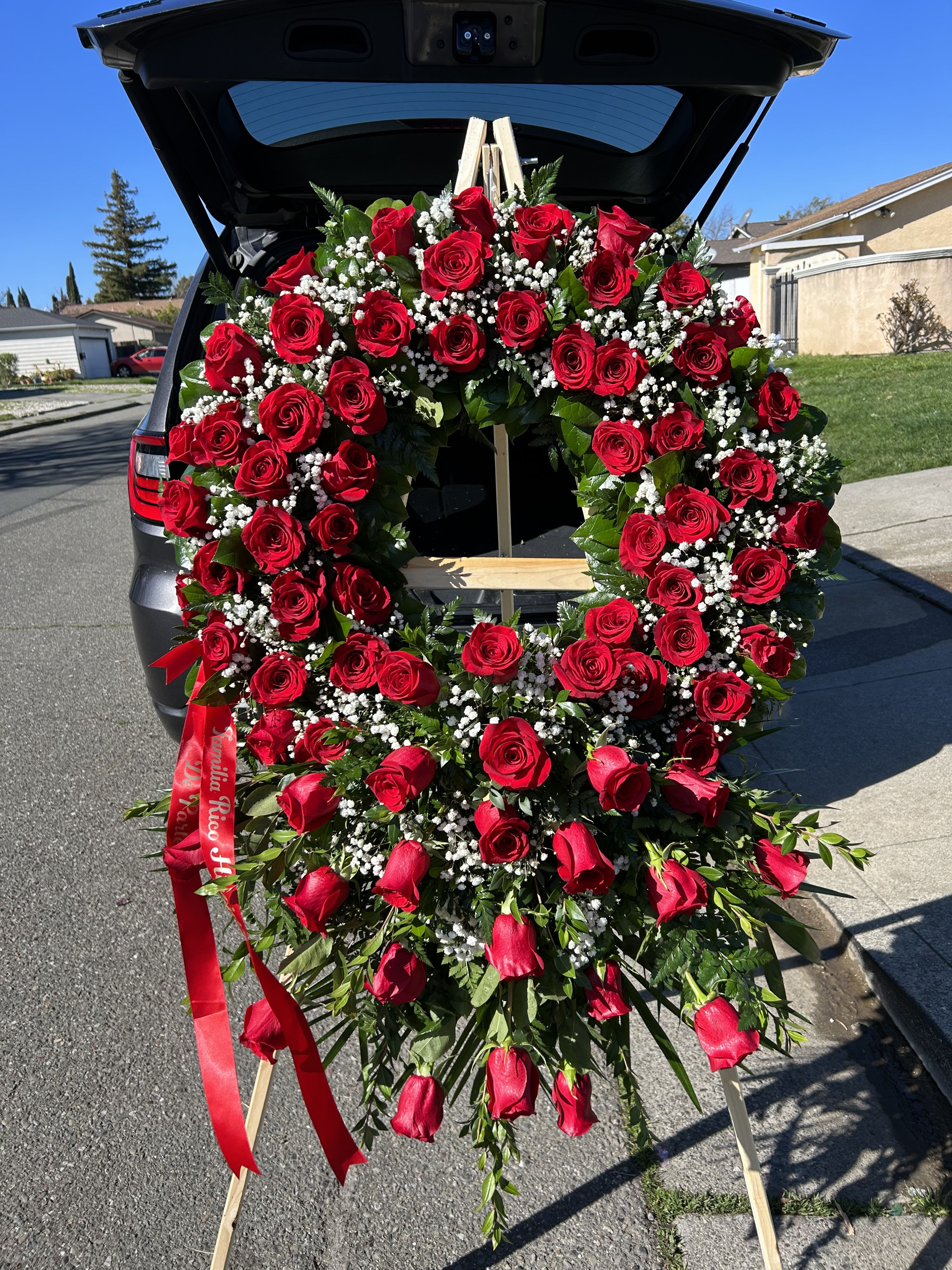 Large heart-shaped wreath of red roses on a standing easel