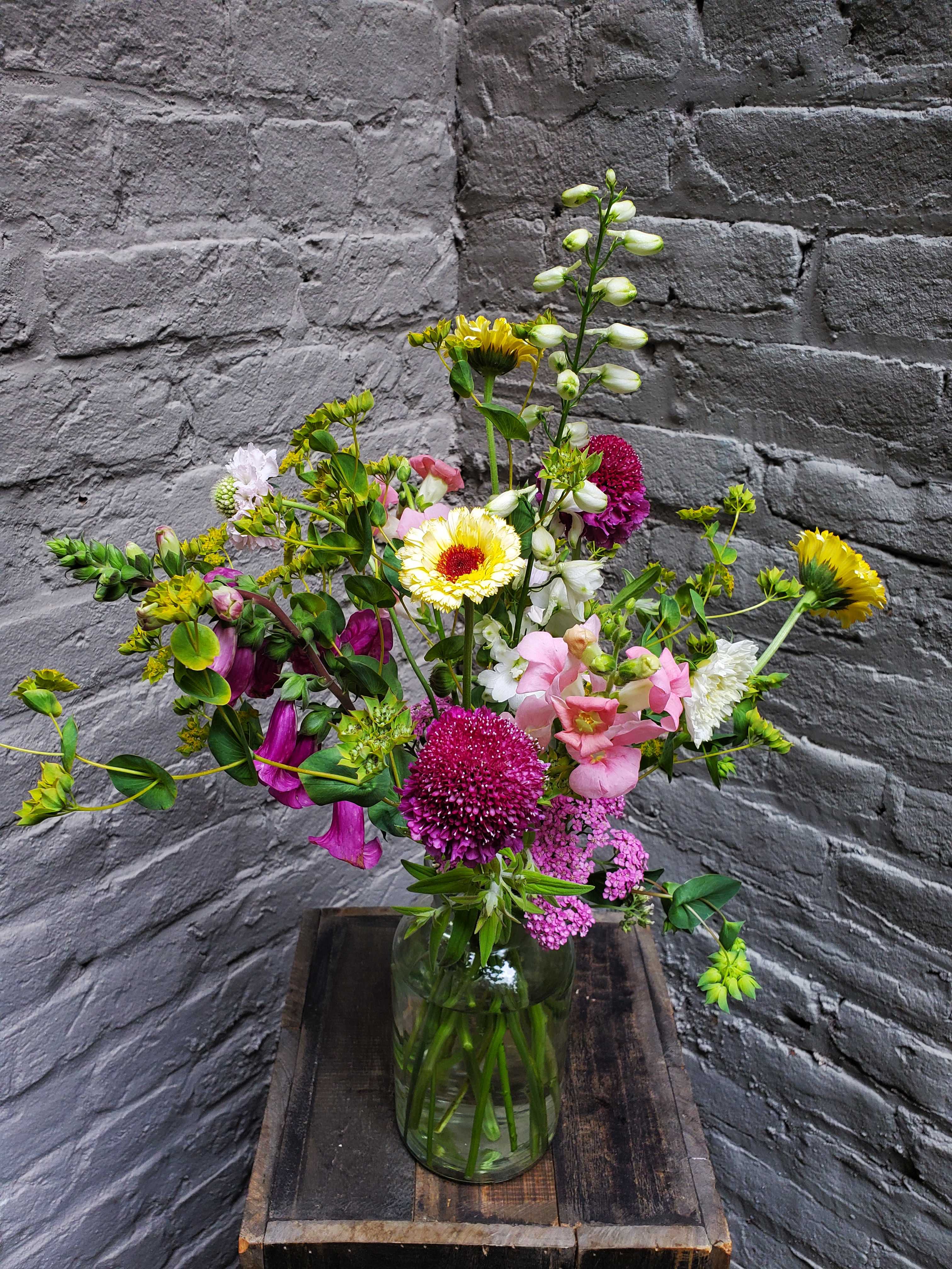Mixed bouquet in a glass vase with pink, white, and yellow flowers