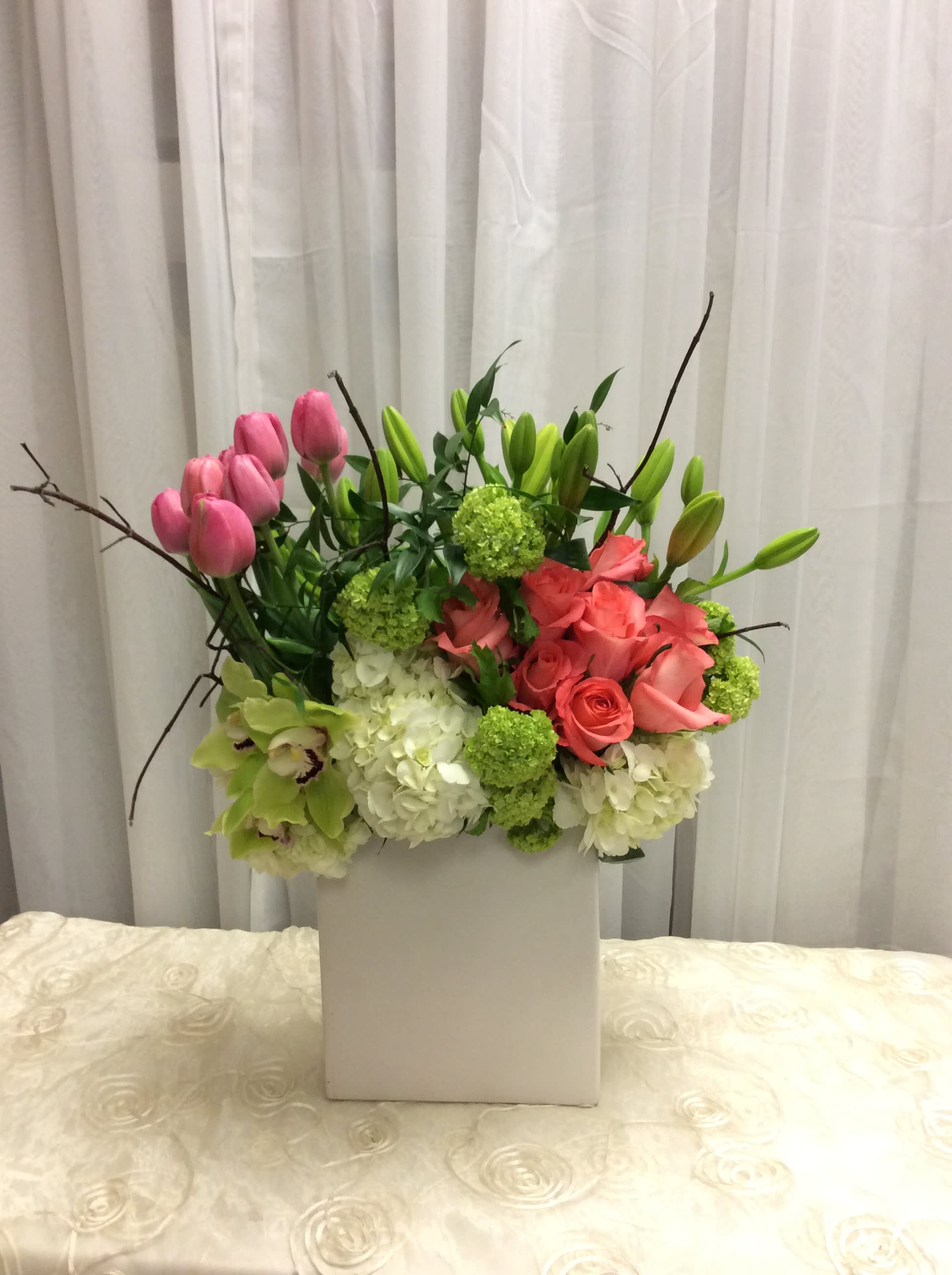 Pink tulips and roses in a white box with green accents