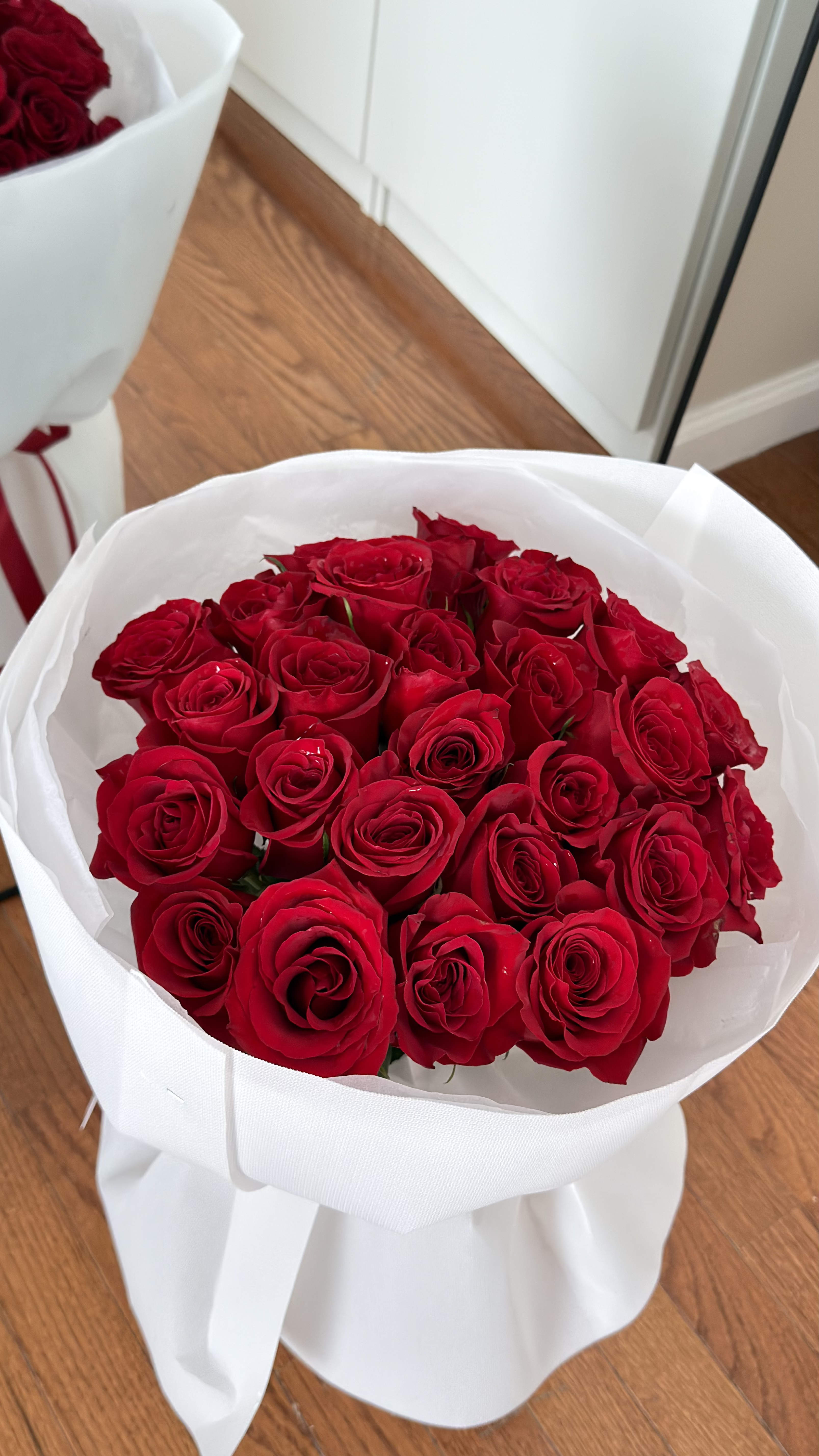Bouquet of red roses wrapped in white paper