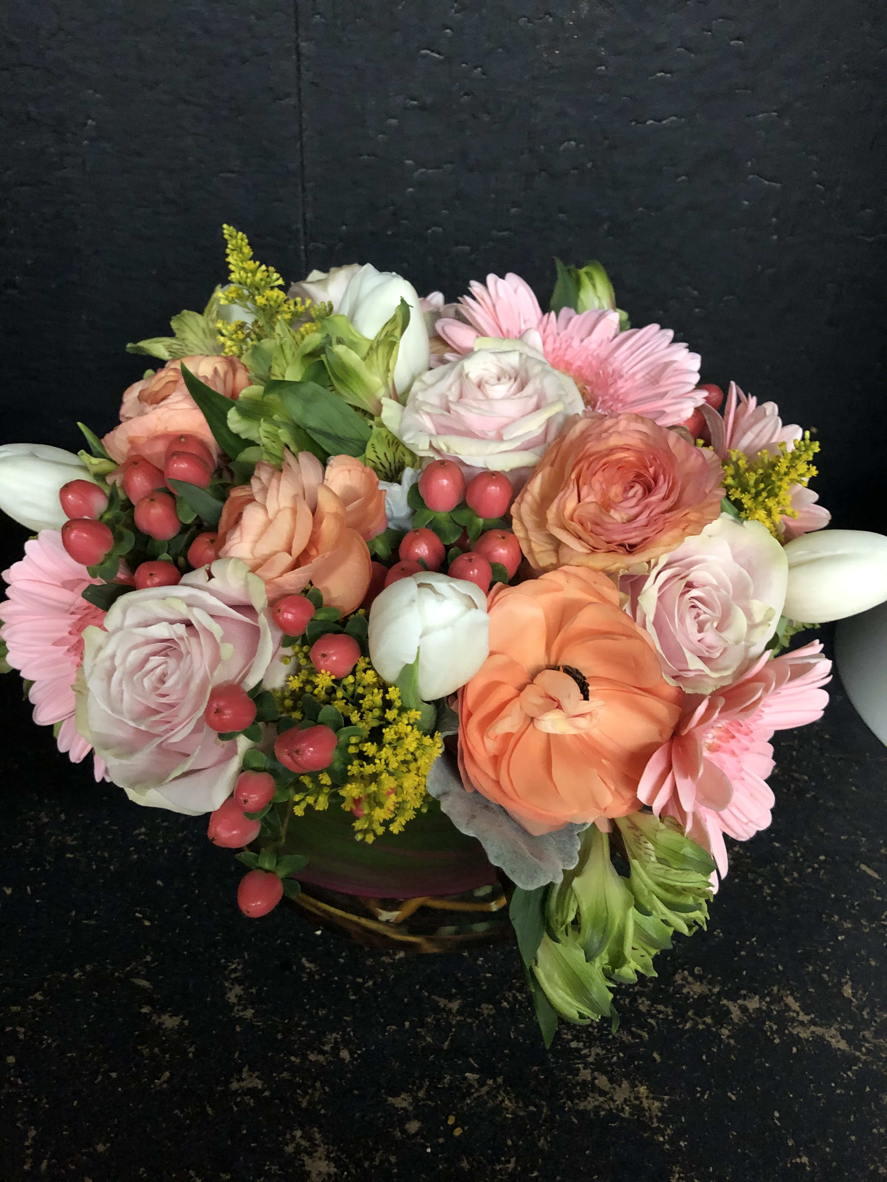Mixed bouquet with pink roses, peach blooms, and pink daisies in a basket