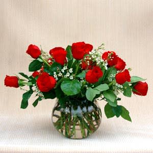 Red roses arranged in a clear glass vase
