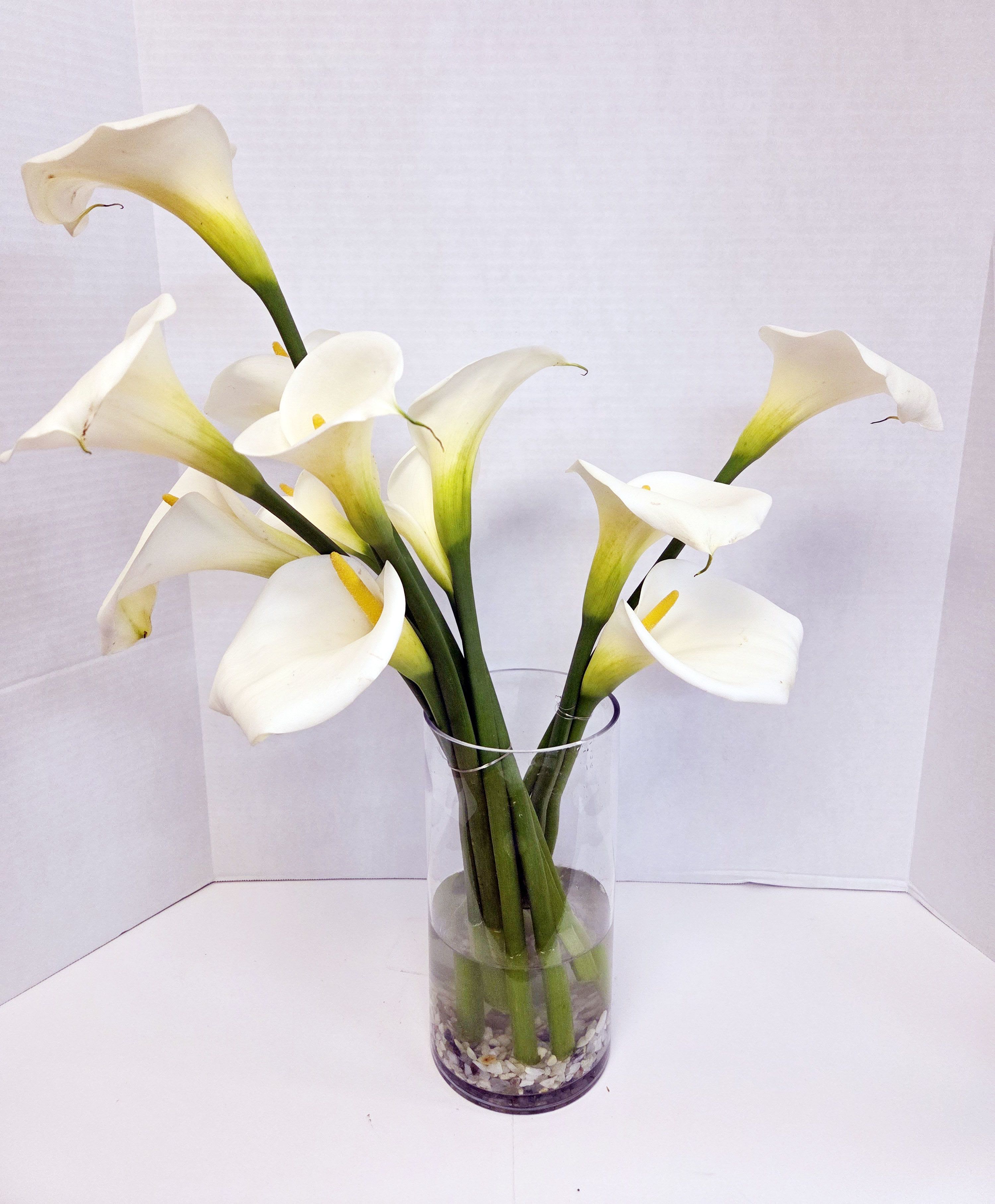 White calla lilies in a clear glass vase