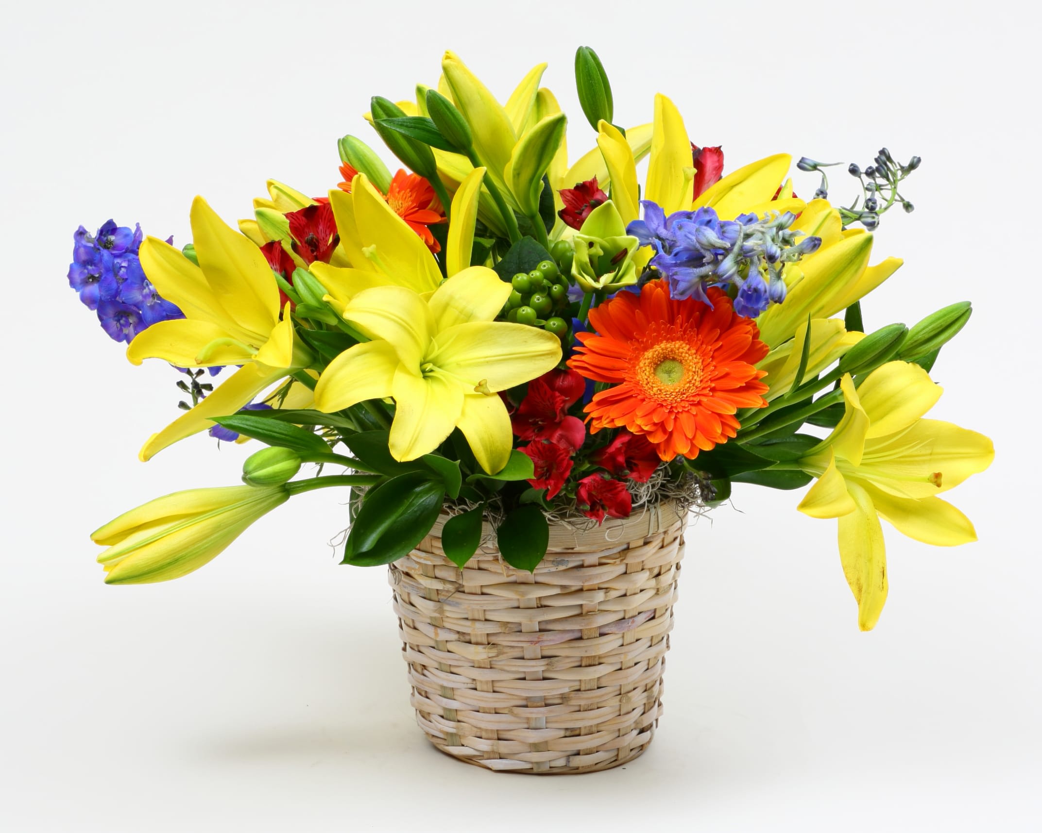 Yellow lilies and mixed flowers in a woven basket