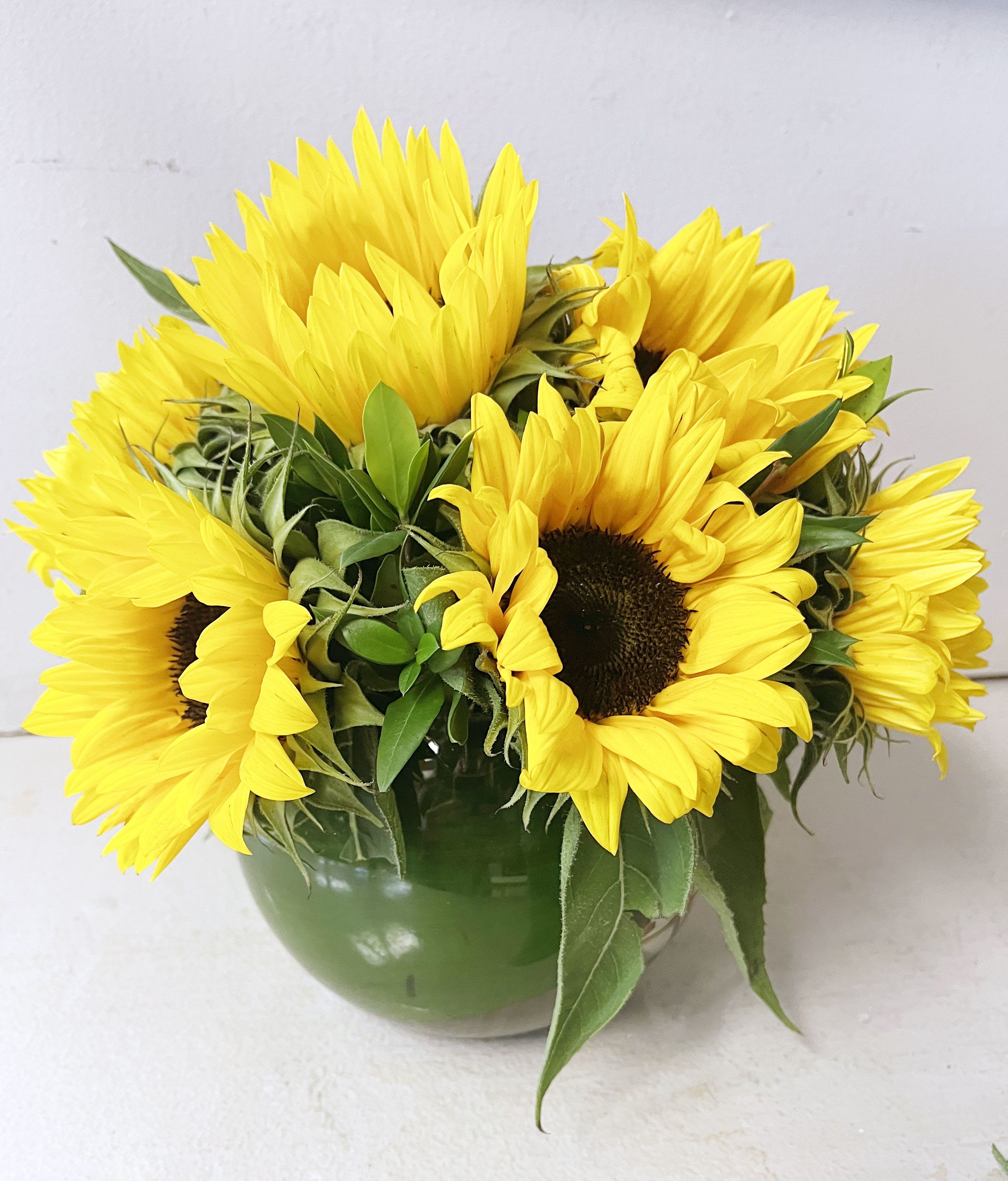 Bouquet of yellow sunflowers in a green vase