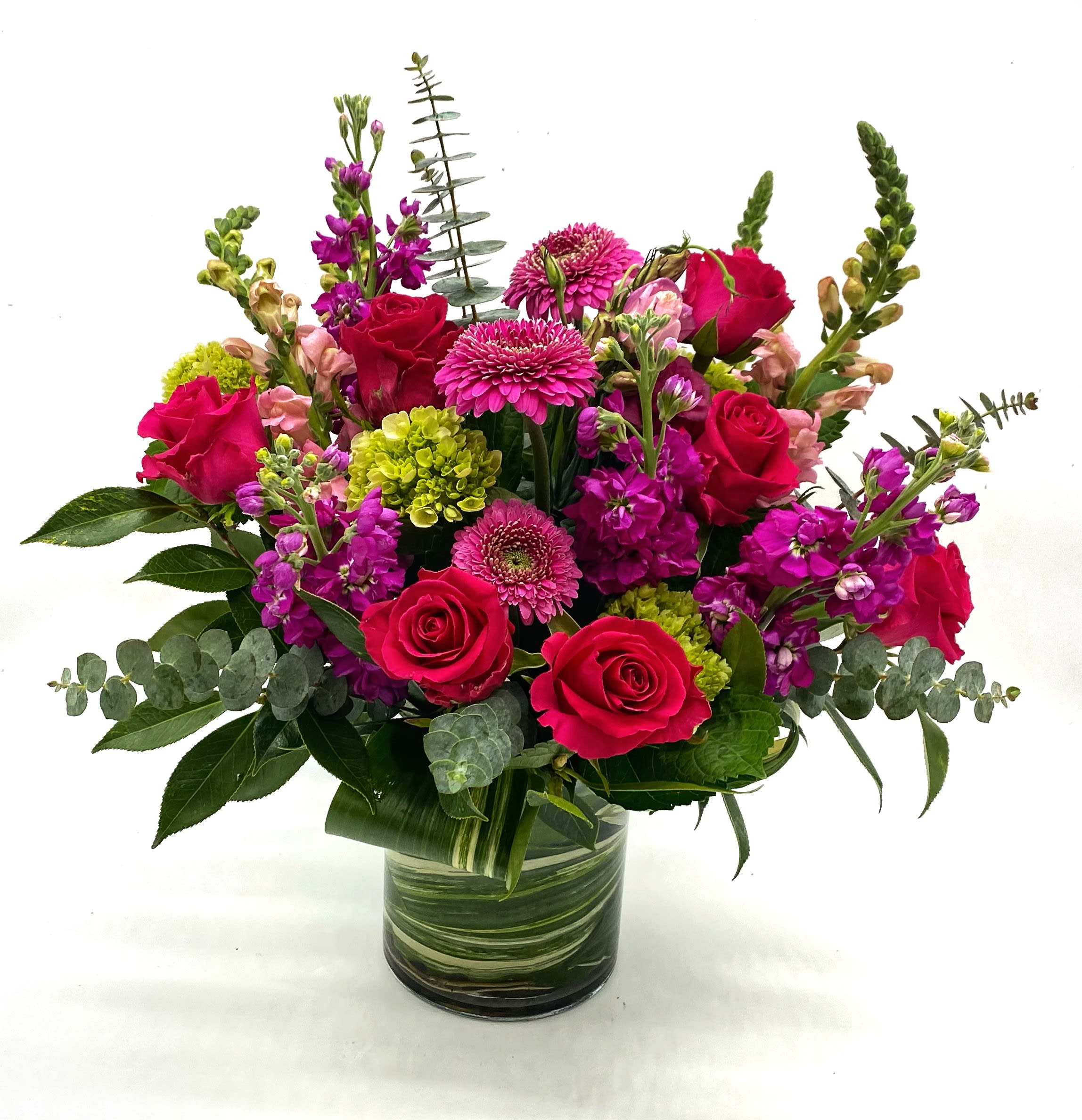 Bouquet of pink roses and magenta flowers in a glass vase