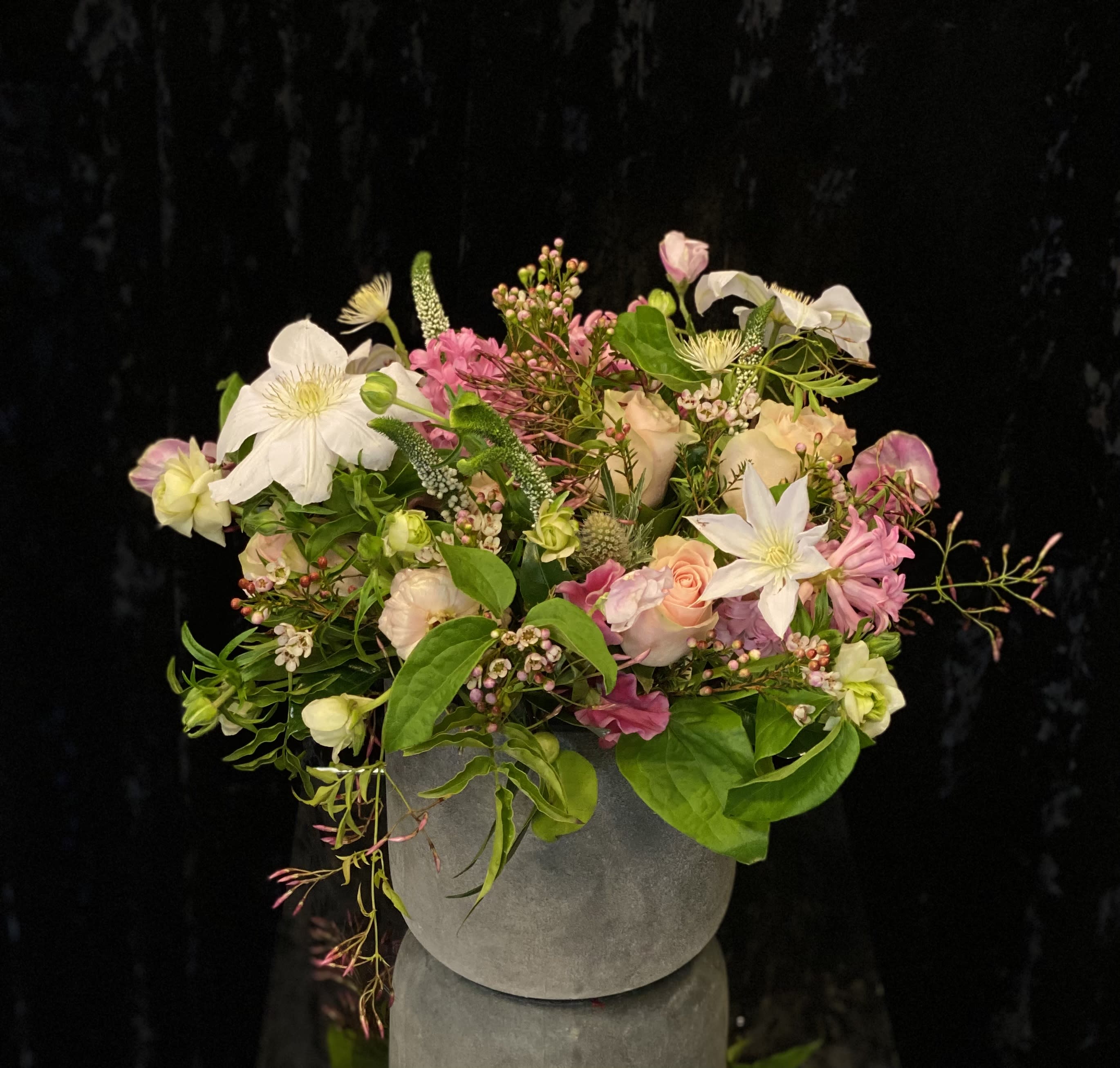 Mixed pink and white floral arrangement in a gray vase