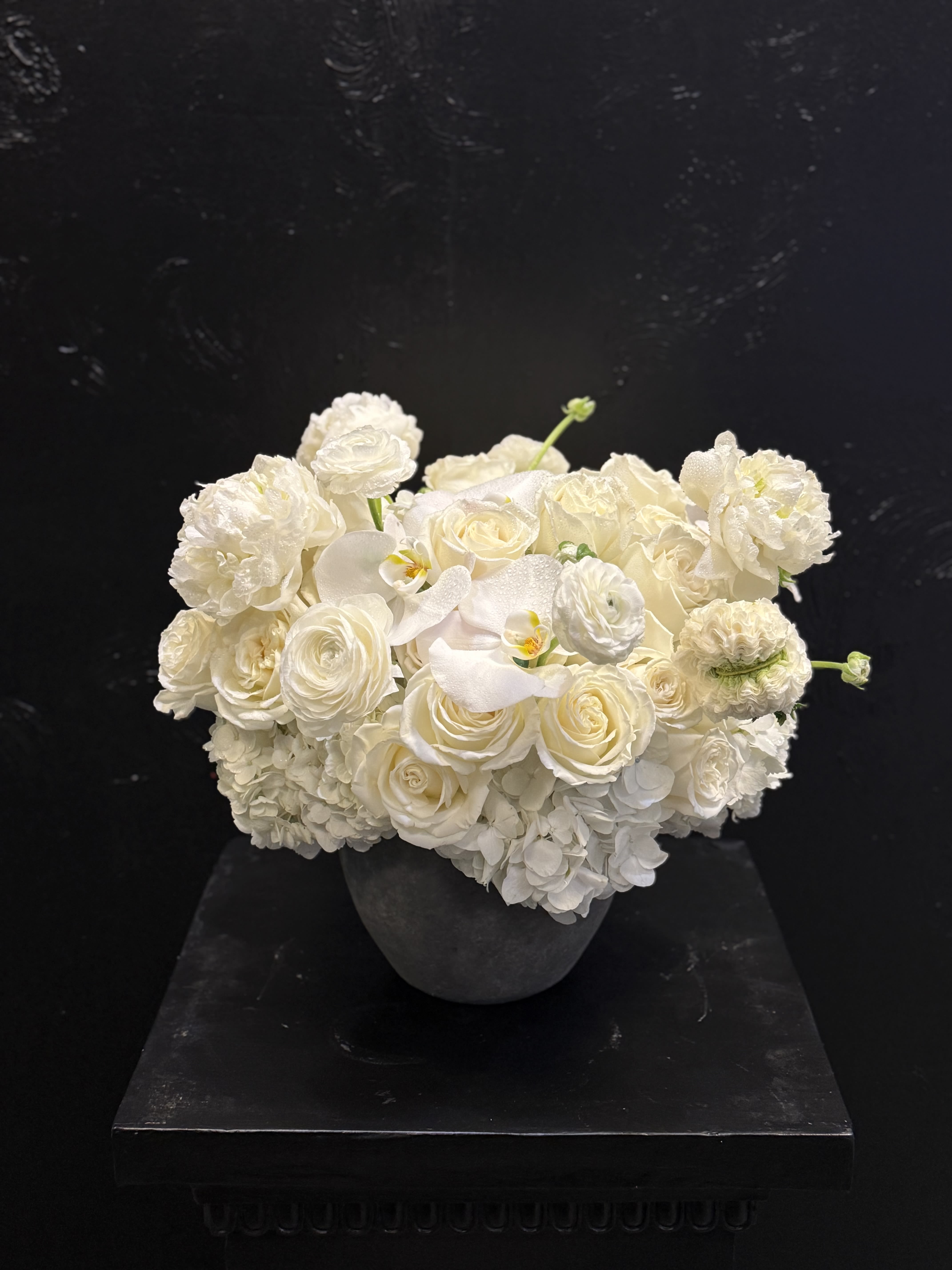 White rose and hydrangea arrangement in a dark vase