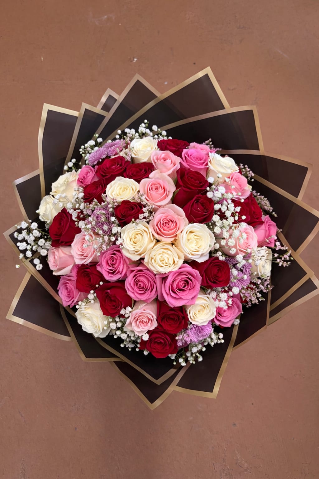 Bouquet of pink, red, and white roses with baby's breath