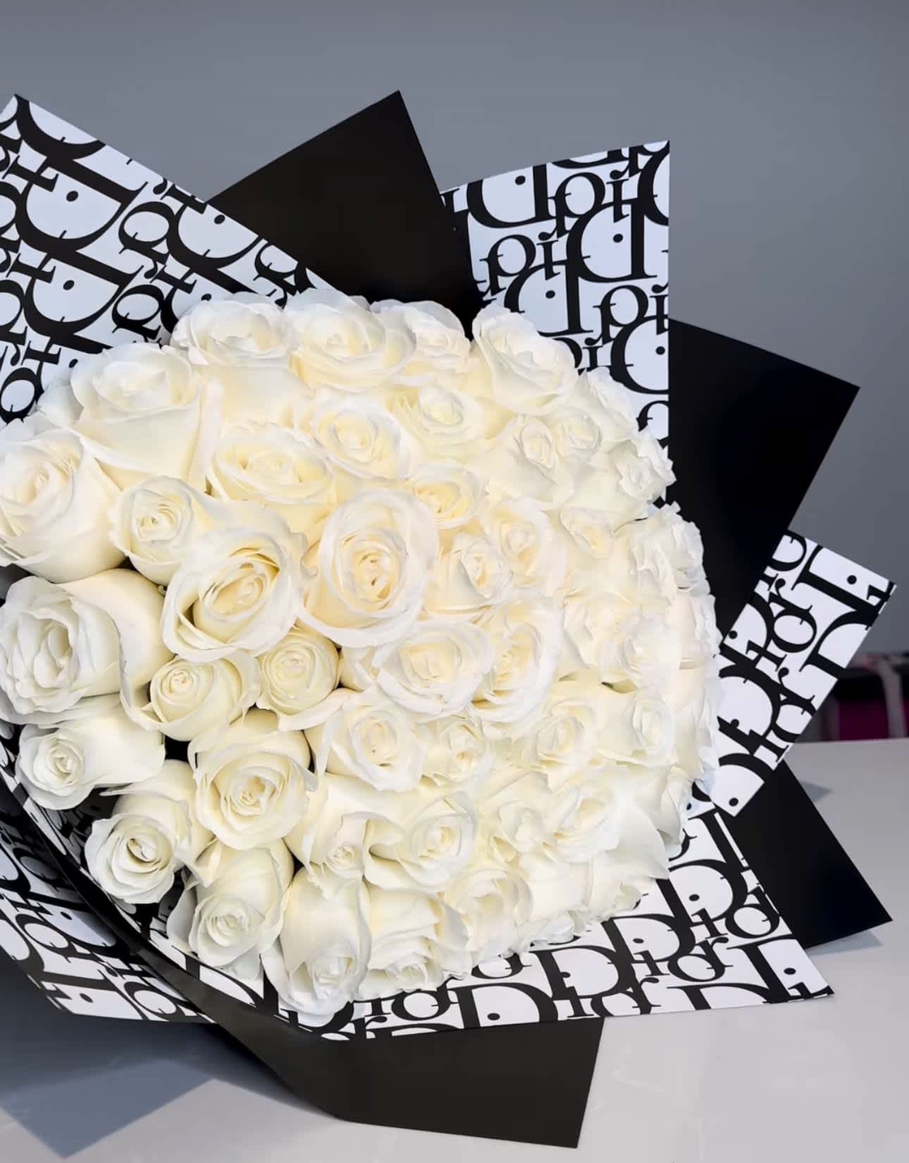Dior White arrangement   - For classic romance two dozen white roses is always the perfect choice. 2 to 4 dozen long-stemmed white roses in a Dior paper wrap   standard 2 dozen Deluxe 3 dozen Premium 4 dozen 