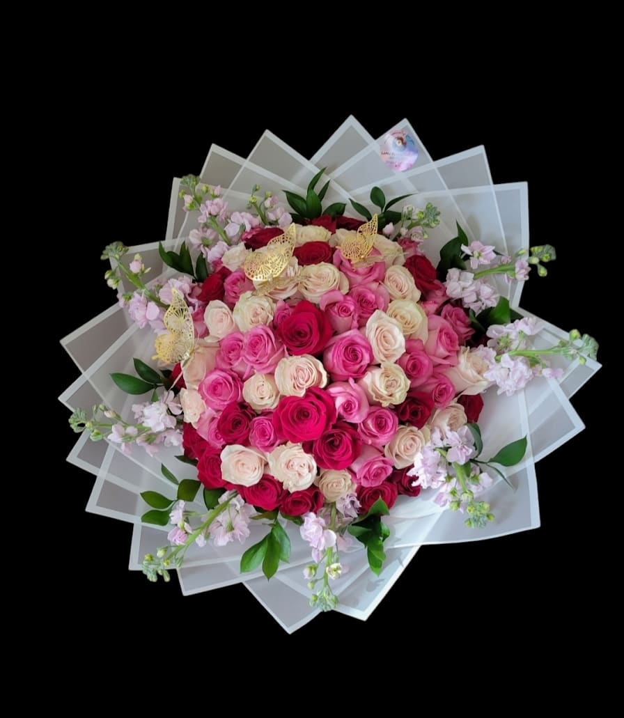 Large bouquet of pink and cream roses with translucent wrapping