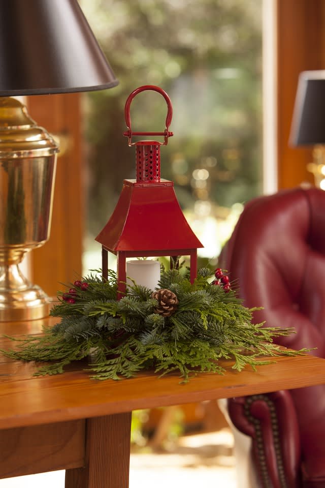 Red lantern centerpiece with evergreen and a candle