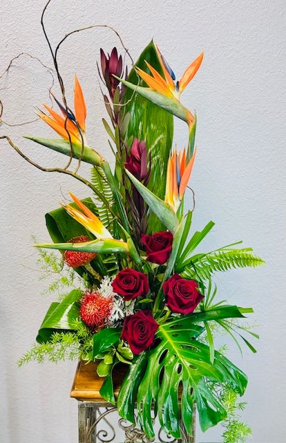 Tropical arrangement with red roses and bird of paradise flowers