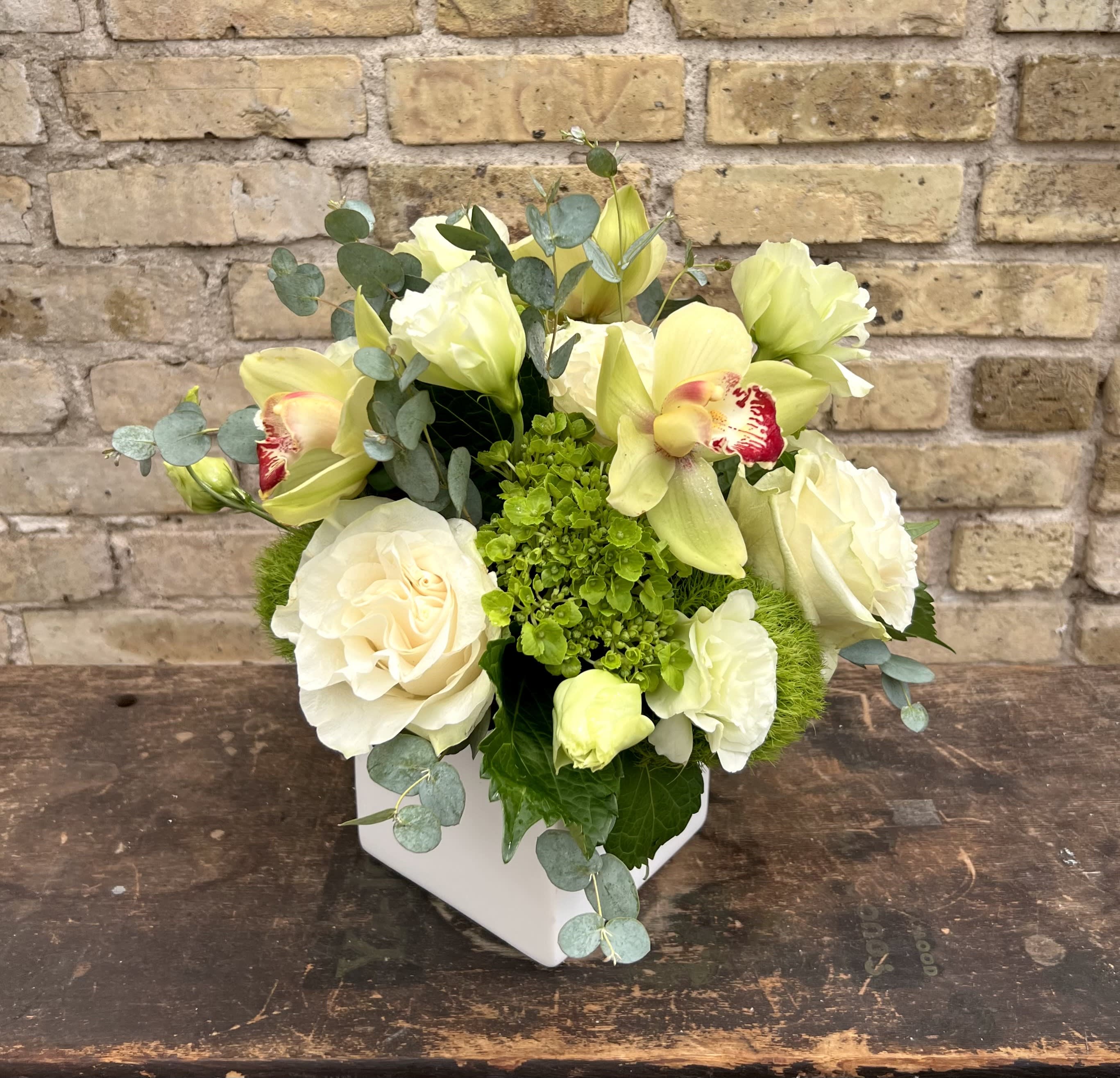 Lady of Dreams - Fresh Arrangement Using an Assortment of Lisianthus, Hydrangea, Roses, Cymbidium Orchids in a White Ceramic Container.