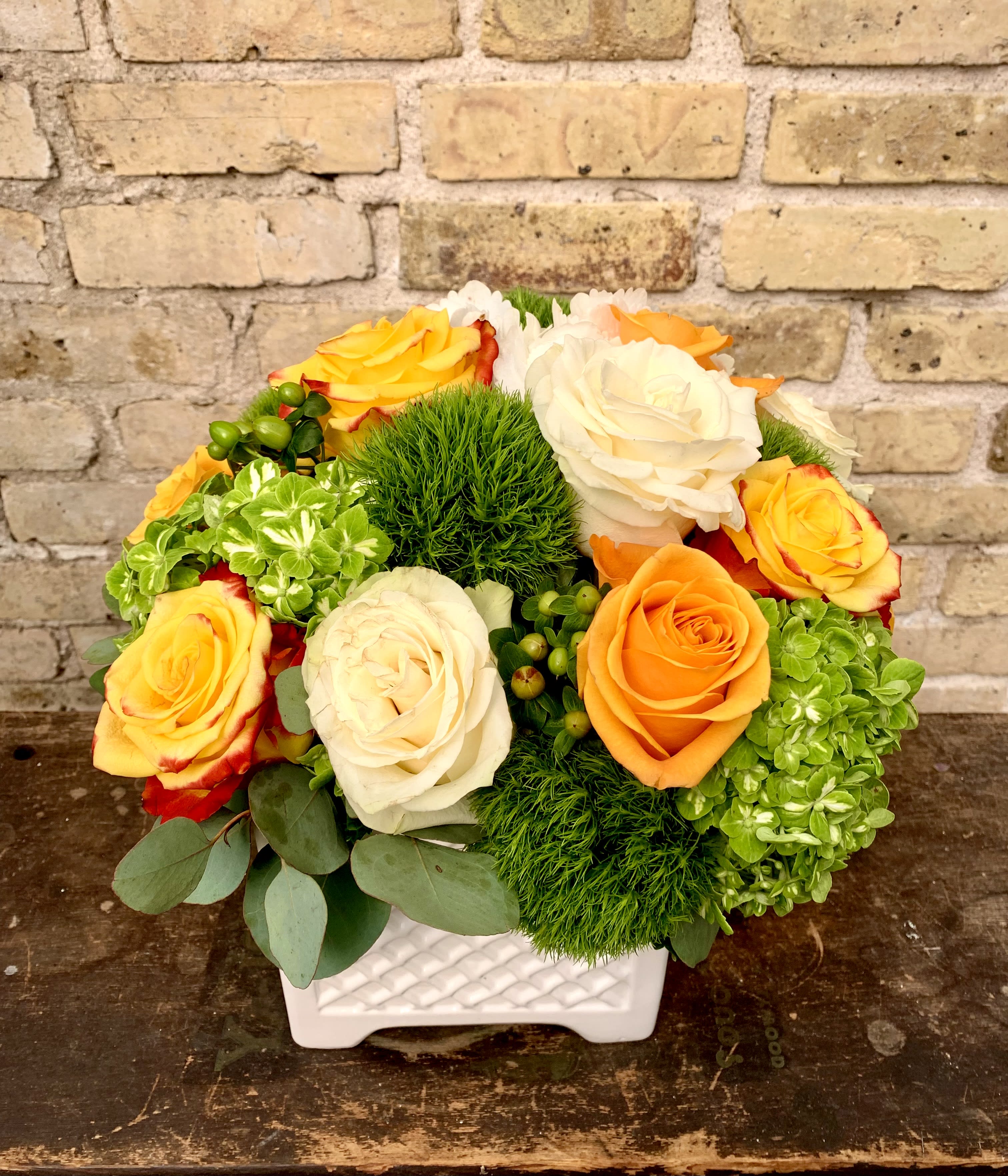 Belles Fleurs - Nice Bright Floral Using an Assortment of Orange and White Roses, Hypericum and Hydrangea Designed in a White Ceramic Container.