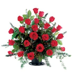 Red roses arranged in a black vase with greenery