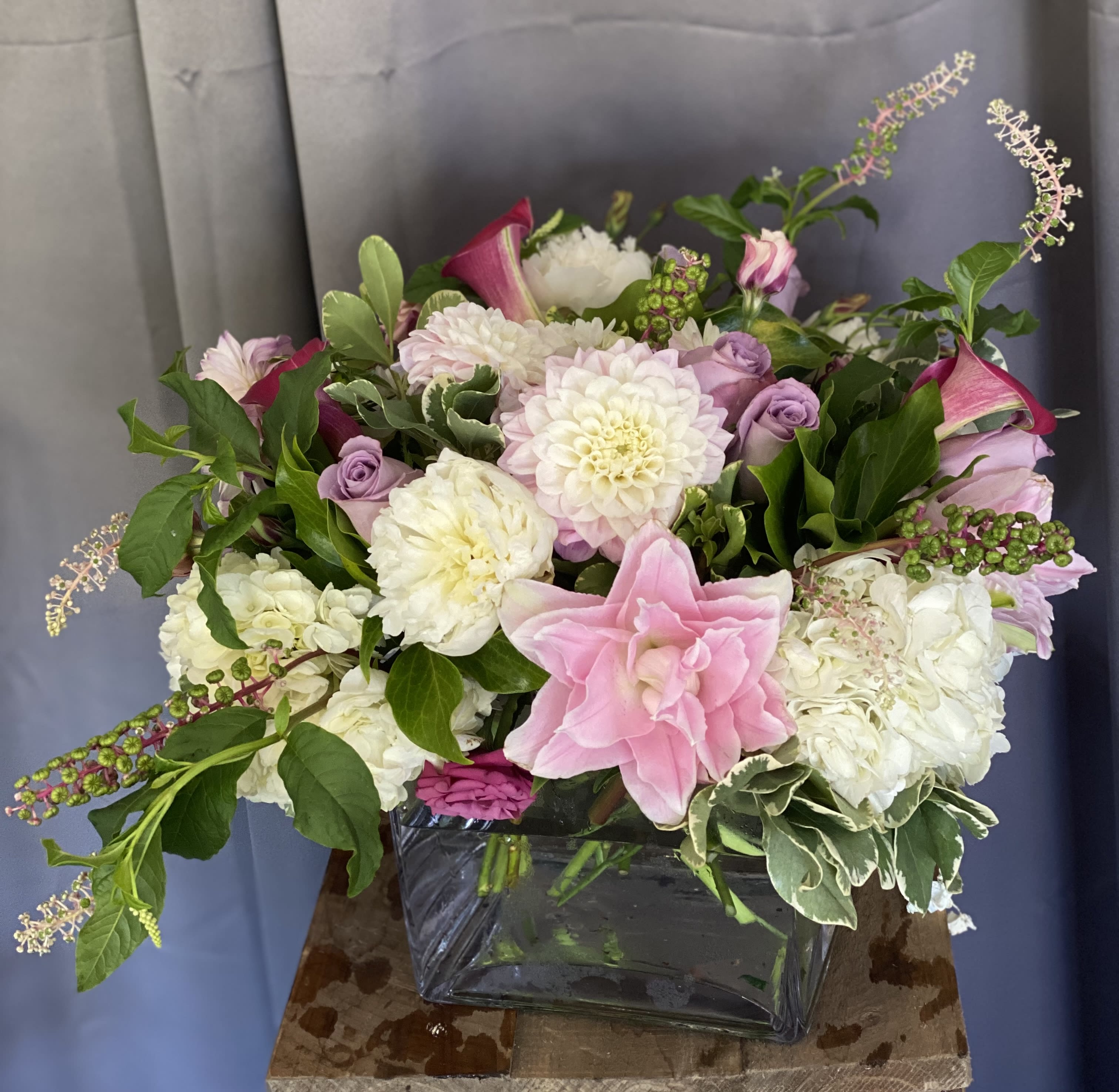 Pink and white floral arrangement in a square glass vase
