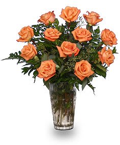 Orange roses arranged in a clear glass vase
